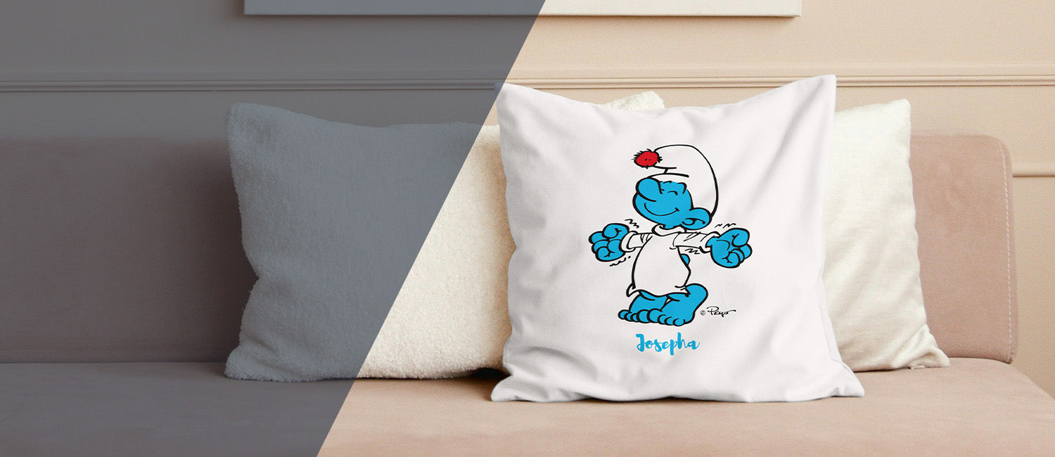 Weißes personalisiertes Schlumpf Kissen mit Namen Josepha für Fans der Zeichentrickserie auf beigem Sofa.