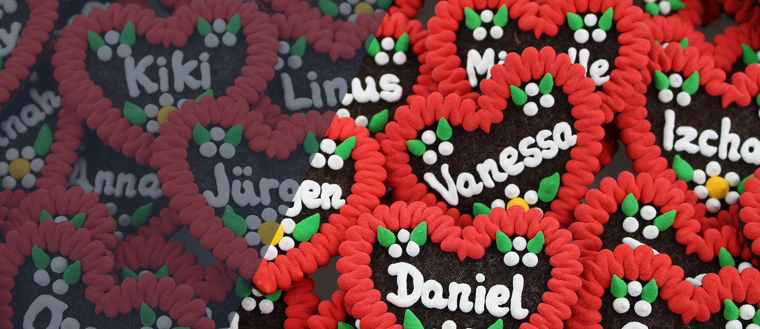 Vielfältige bayerische Filzherz-Anstecker mit weißen Namen und traditioneller roter Umrandung, ideal als personalisiertes Geschenk.