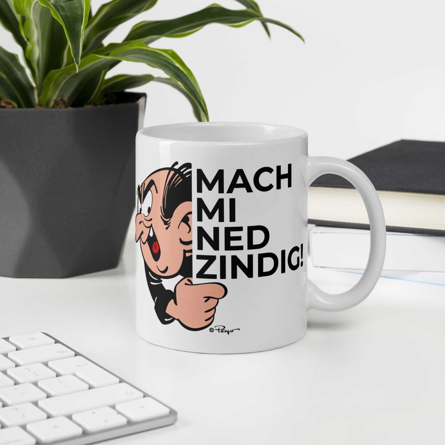 Weiße Porzellan-Tasse mit Henkel und farbigem Schlumpf-Motiv sowie dem Schriftzug „Mach mi ned zindig“, 330 ml.