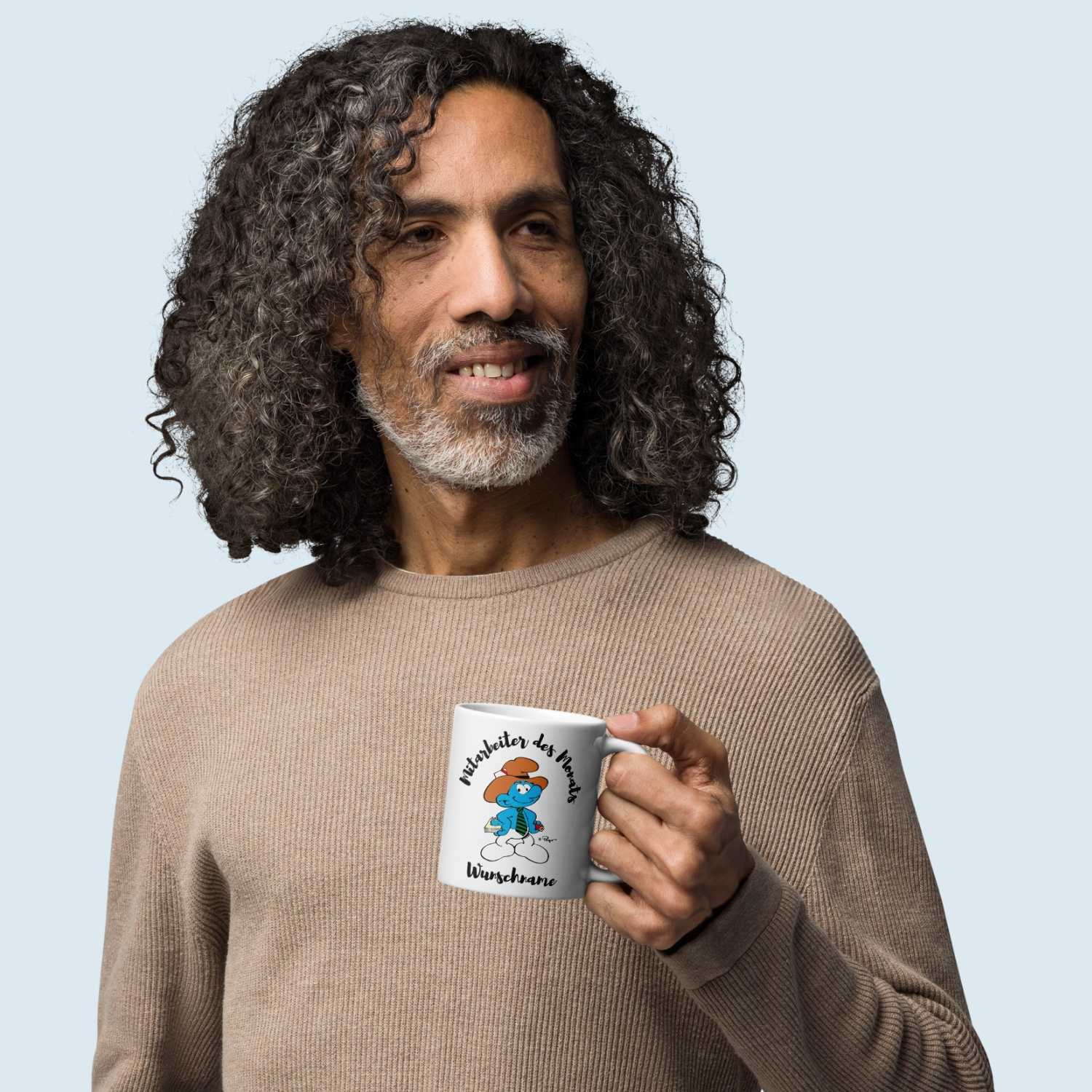 Weiße Porzellantasse mit Schlumpf-Motiv und schwarzem Schriftzug „Mitarbeiter des Monats“, ca. 330 ml.