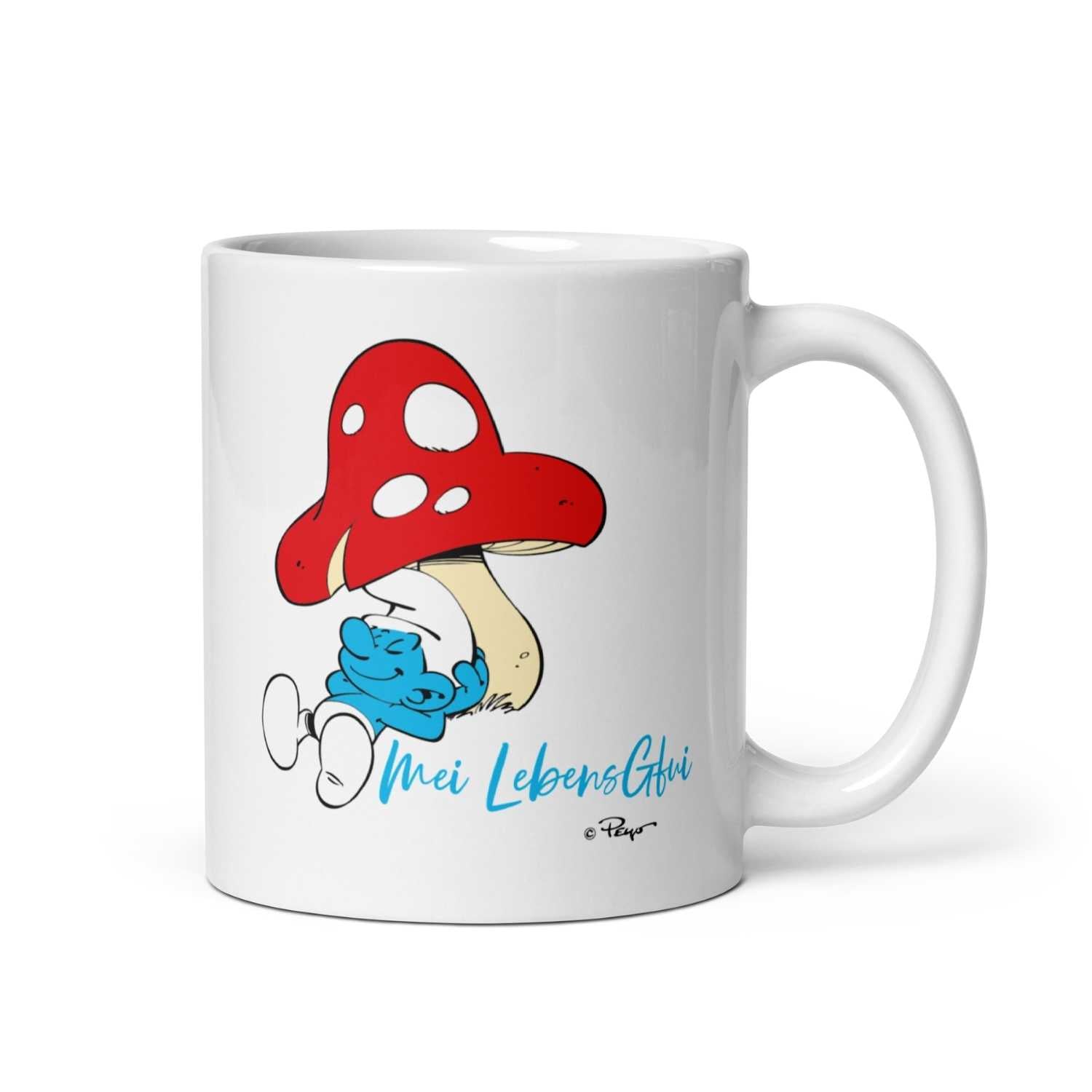 Weiße Porzellantasse mit Aufdruck „Do legst di nieda“ und Schlumpf-Motiv gegenüber dem Henkel, 330 ml.