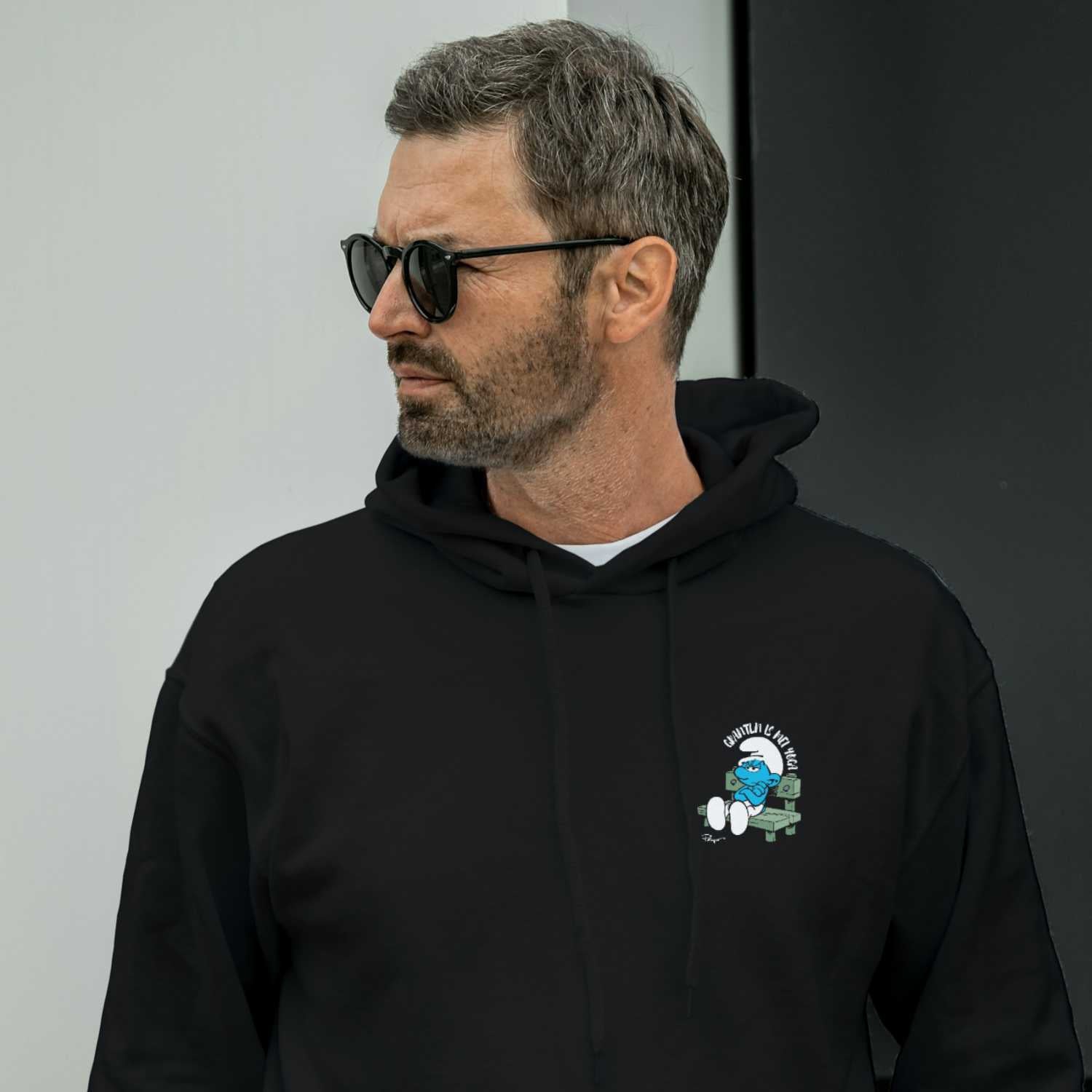 Herren Hoodie mit Kapuze, Frontprint „Grantln is mei Yoga“, mit Schlümpfe-Motiv, aus Bio-Baumwolle und Recycling-Polyester.