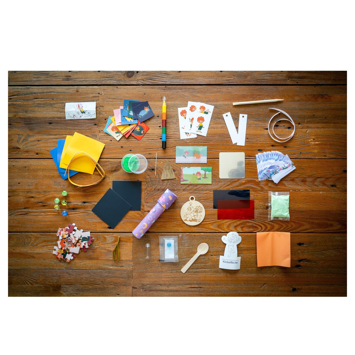 Inhalt des Pumuckl Experimente-Adventskalenders: Bastelmaterial, Knete, Murmeln, Puzzle, Holzanhänger und Karten