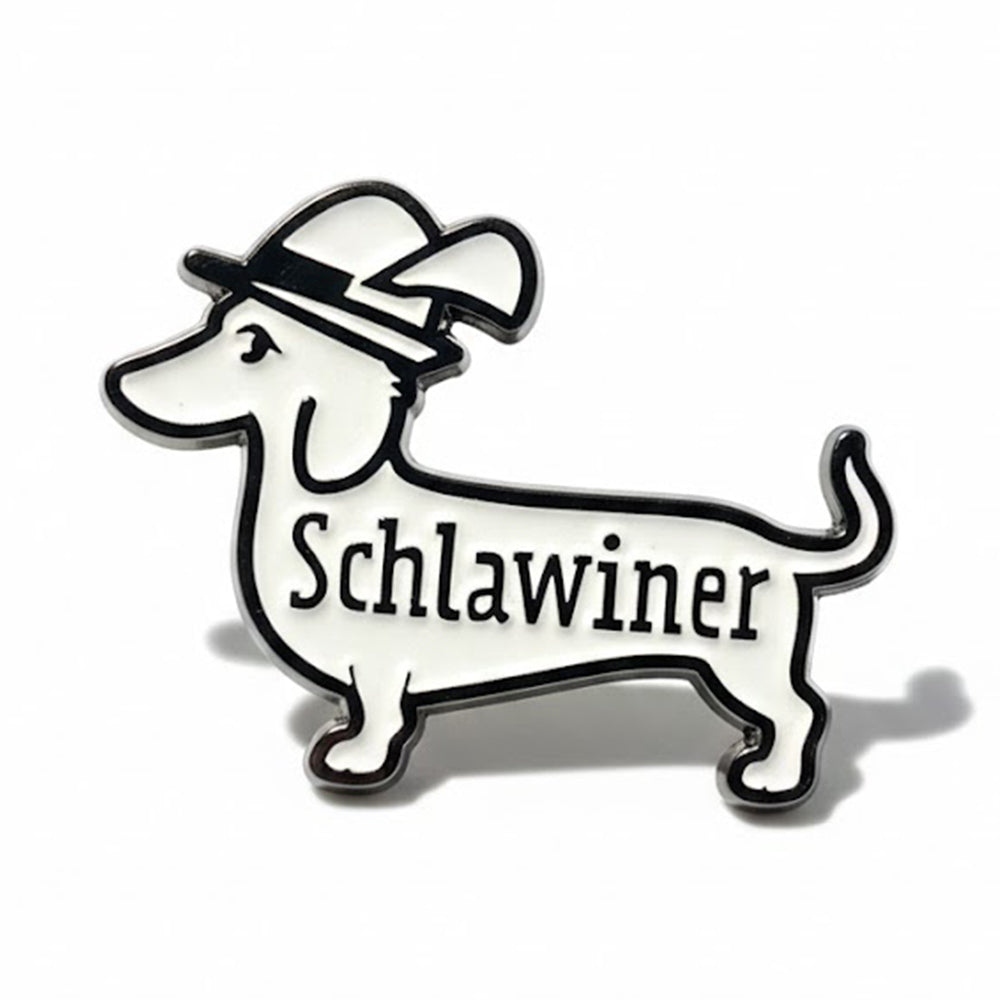 Emaille-Pin in Dackel-Form, schwarz-weiß mit Hut und Schriftzug "Schlawiner", charmantes Accessoire für Dackel-Fans.