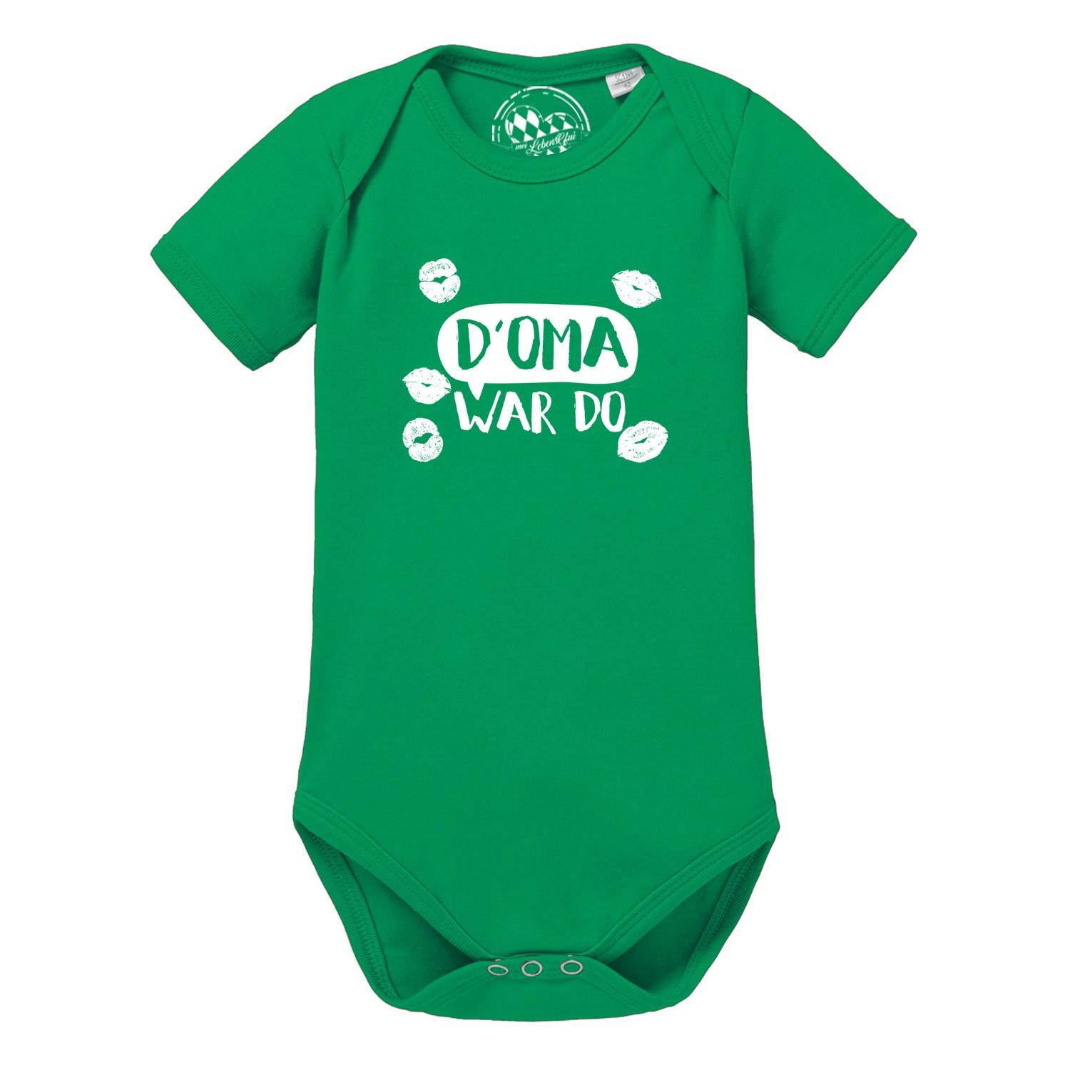 Kurzärmeliger, weißer Babybody mit dunkelblauem Schriftzug „D' Oma war do...“ und bayerischem Herzmotiv; aus Baumwolle.