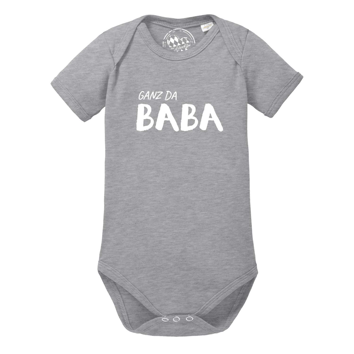 Kurzärmliger Babybody in Weiß mit dunkelblauem Schriftzug „Ganz da Baba!“ auf der Brust; aus Baumwolle.