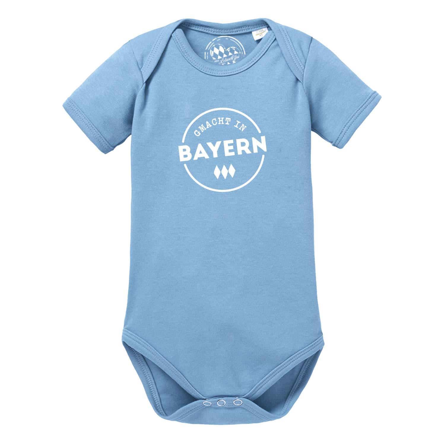 Hellblauer Babybody mit kurzem Arm, Aufdruck „gmacht in Bayern“ in Weiß, bayerisches Herzmotiv, aus Baumwolle.