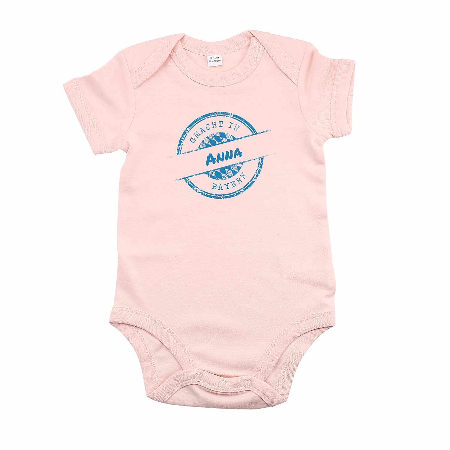 Rosa Baby-Body mit weißem Aufdruck „gmacht in Bayern“ und individualisierbarem Namensfeld, Druckknöpfe unten, Baumwolle.