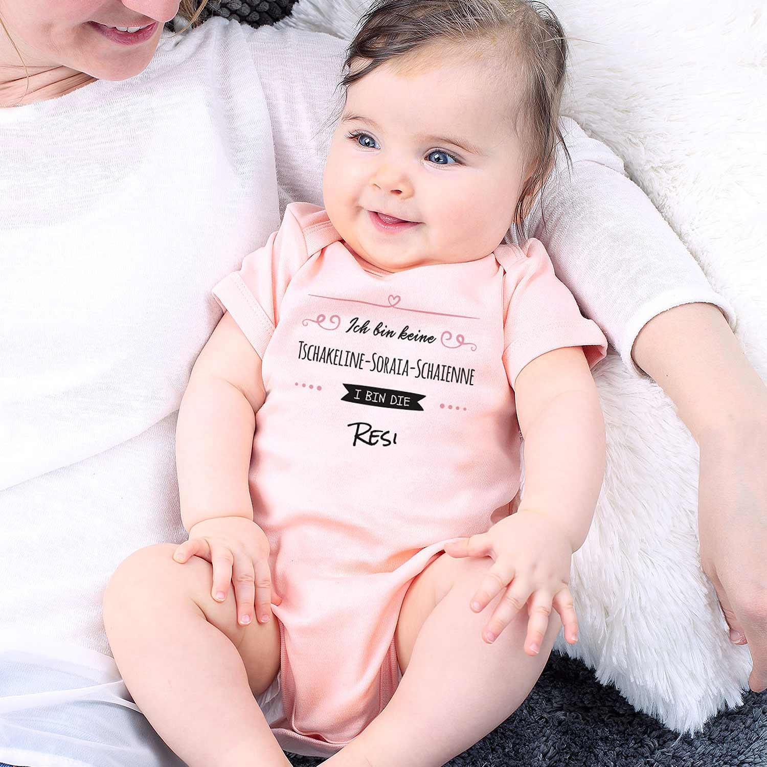 Weißer Babybody mit schwarzem Aufdruck „I bin die Wunschname“, Kurzarm, Rundhalsausschnitt, Druckknöpfe im Schritt, Baumwolle.
