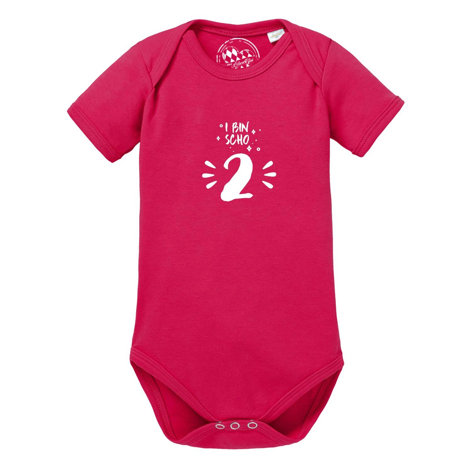 Kurzärmeliger, weißer Babybody mit rundem Halsausschnitt und blauem Schriftzug „I bin scho 2!“, aus Baumwolle.