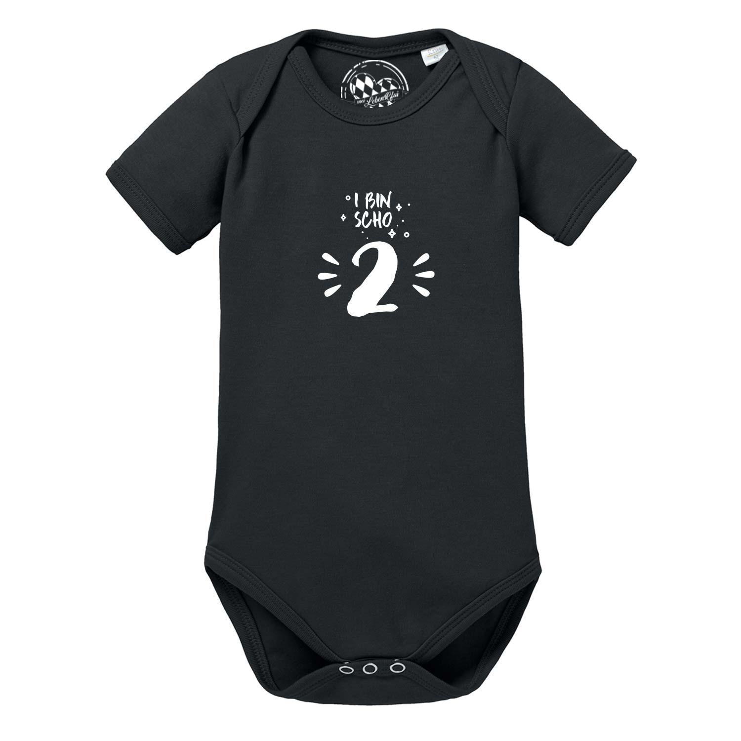 Weißer Baby-Body mit kurzen Ärmeln und blauem Schriftzug „I bin scho 2!“ auf der Vorderseite; aus Baumwolle.