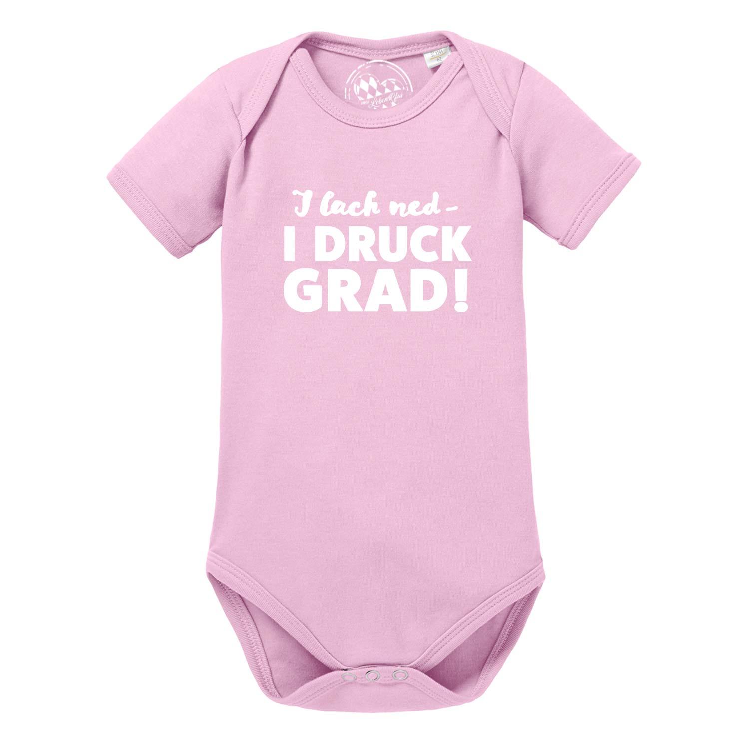 Weißer Babybody mit kurzen Ärmeln, schwarzem Schriftzug „I lach ned...“ und runder Halsausschnitt aus Baumwolle.