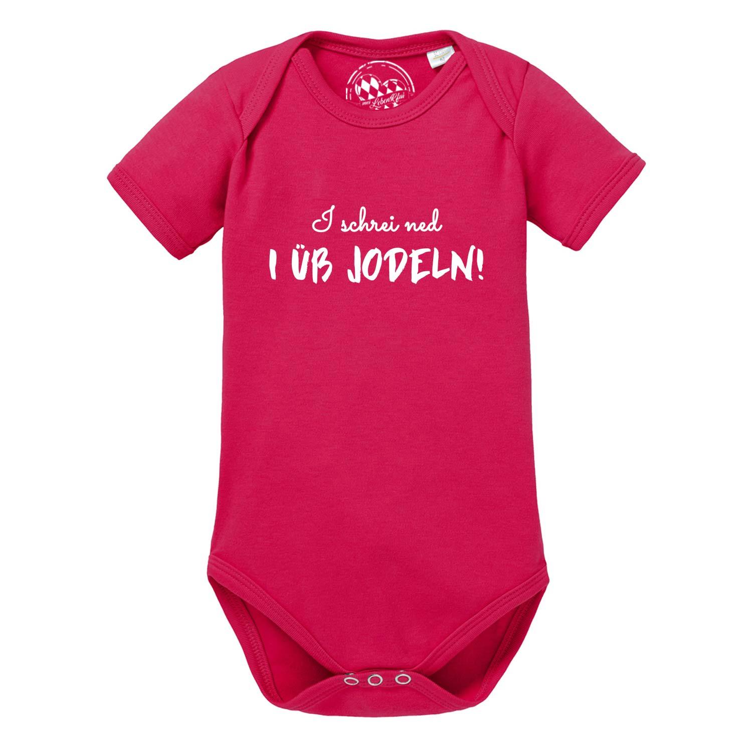 Weißer Babybody mit kurzem Arm und blauem Aufdruck „I üb jodeln“ in Handschrift-Optik, aus Baumwolle.