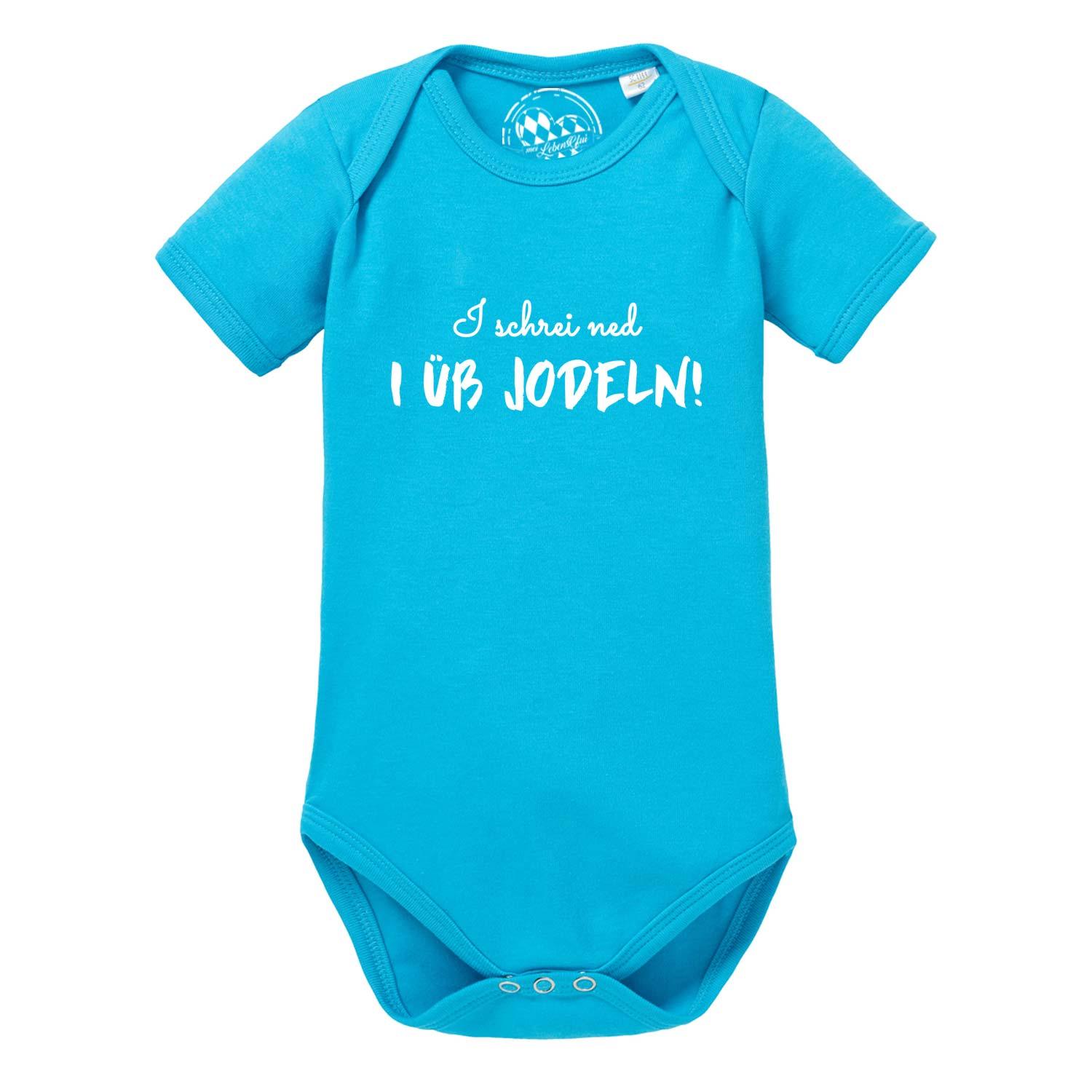 Weißer Babybody mit kurzem Arm, schwarzem Schriftzug „I üb jodeln“ und rot-grauem Edelweiß-Motiv; aus Baumwolle.
