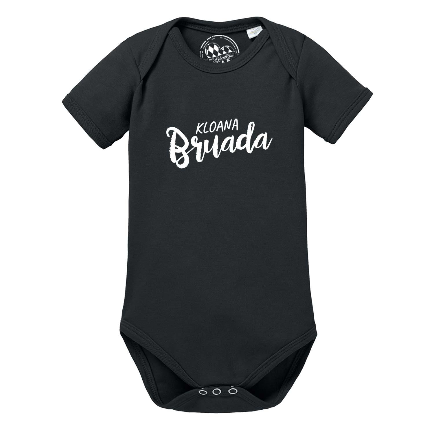 Weißer Babybody mit kurzem Arm, grauem Schriftzug „Kloana Bruada“ und Herzmotiv auf der Brust; aus Baumwolle.