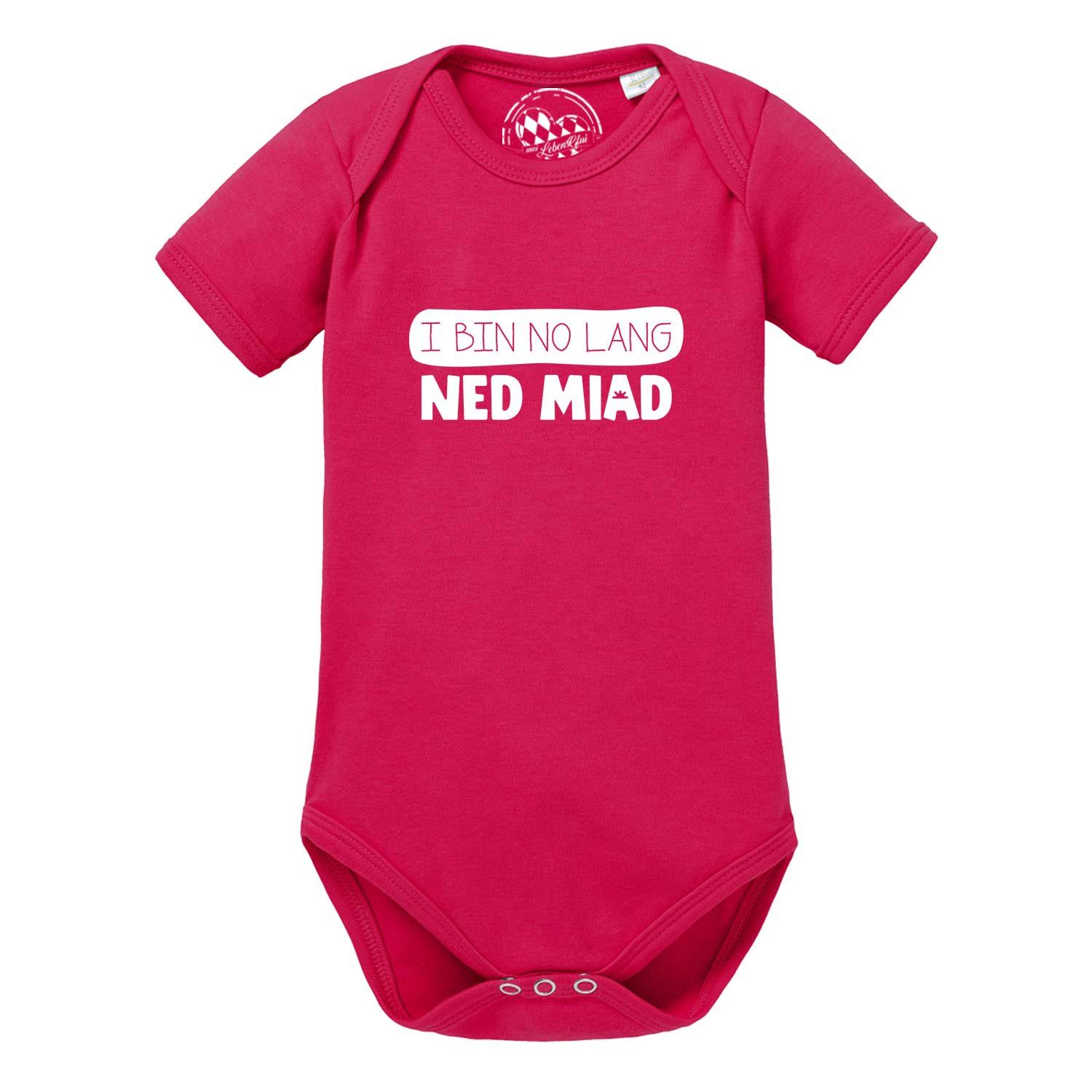 Weißer Babybody mit kurzem Arm, blauem Herz-Motiv und bayerischem Schriftzug „no lang ned miad!“ auf der Brust.
