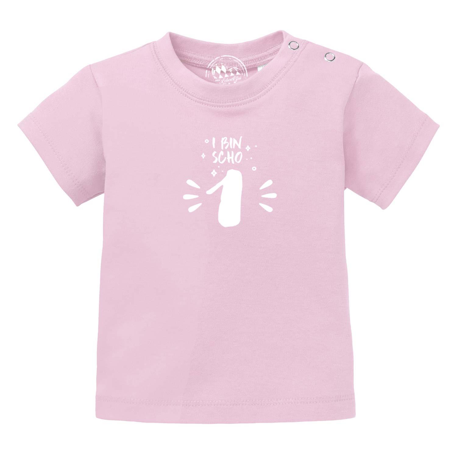 Rosa Baby T-Shirt I bin scho 1 mit weißem Zahlenmotiv und Druckknöpfen an der Schulter.