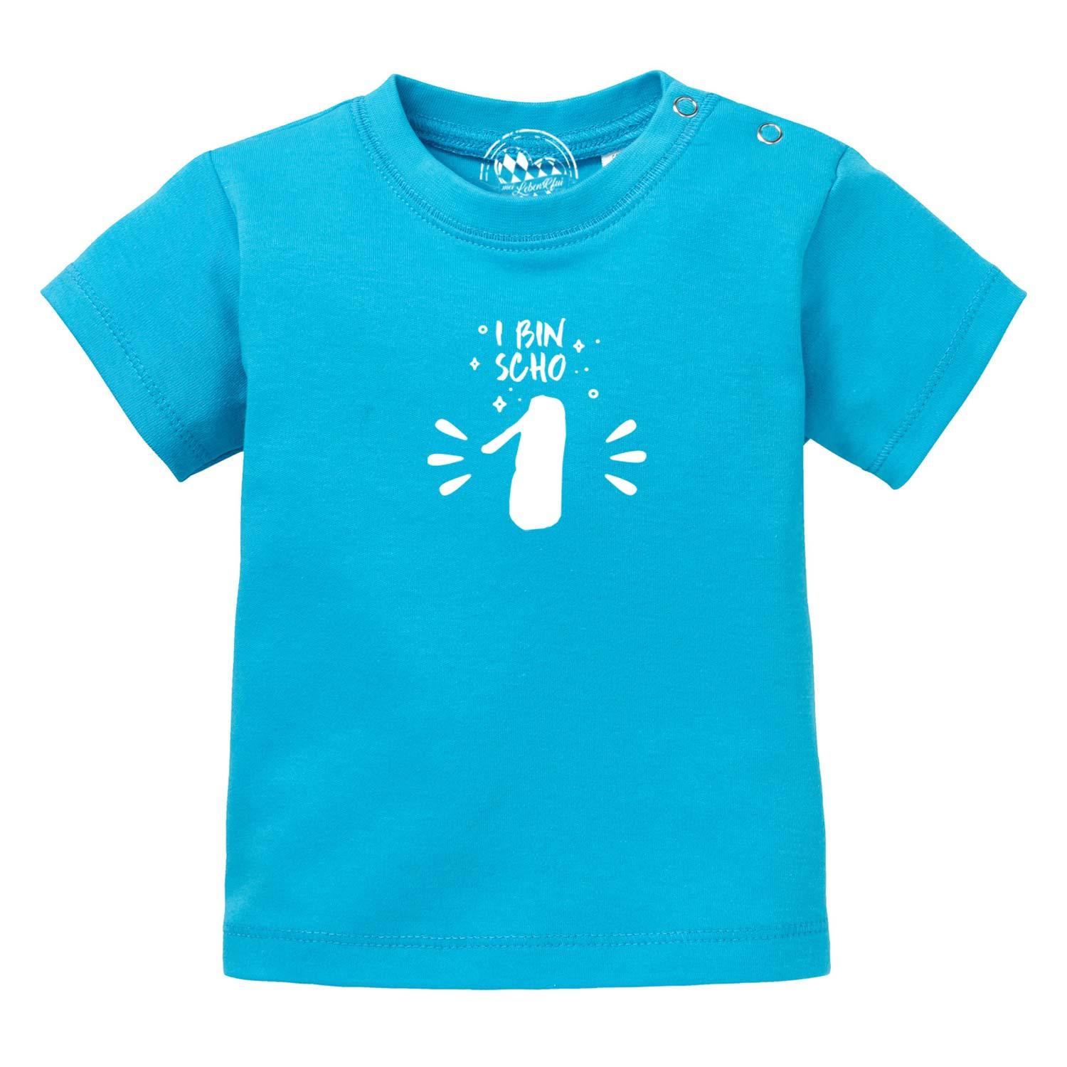 Türkisblaues Baby T-Shirt "I bin scho 1!" mit weißem Aufdruck und praktischen Druckknöpfen an der Schulter.