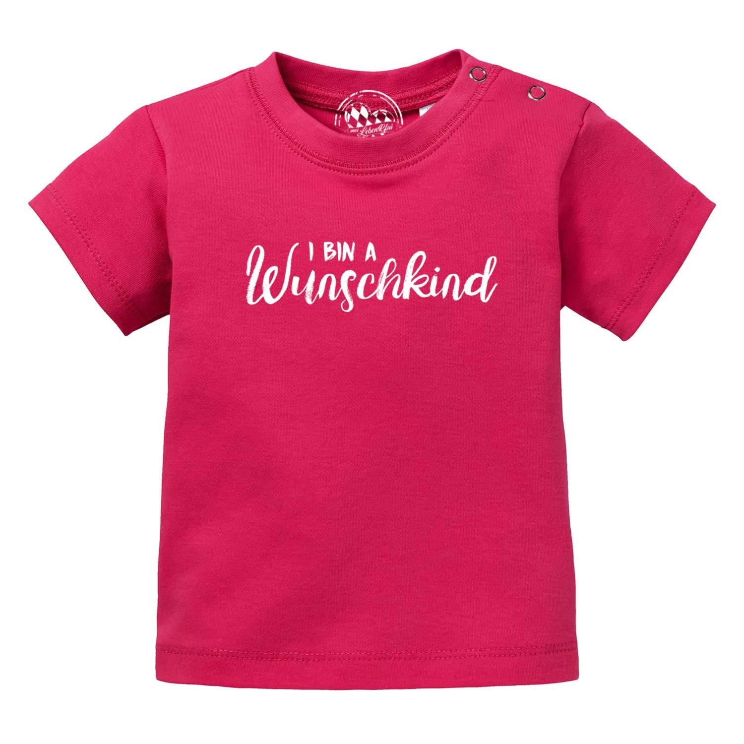 Baby T-Shirt Wunschkind in leuchtendem Pink mit weißem Schriftzug und Druckknöpfen an der Schulter.