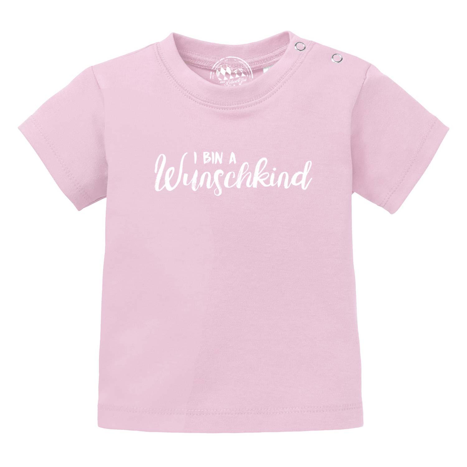 Rosa Baby T-Shirt Wunschkind aus Baumwolle mit weißen Druckknöpfen an der Schulter und weißem Schriftzug.