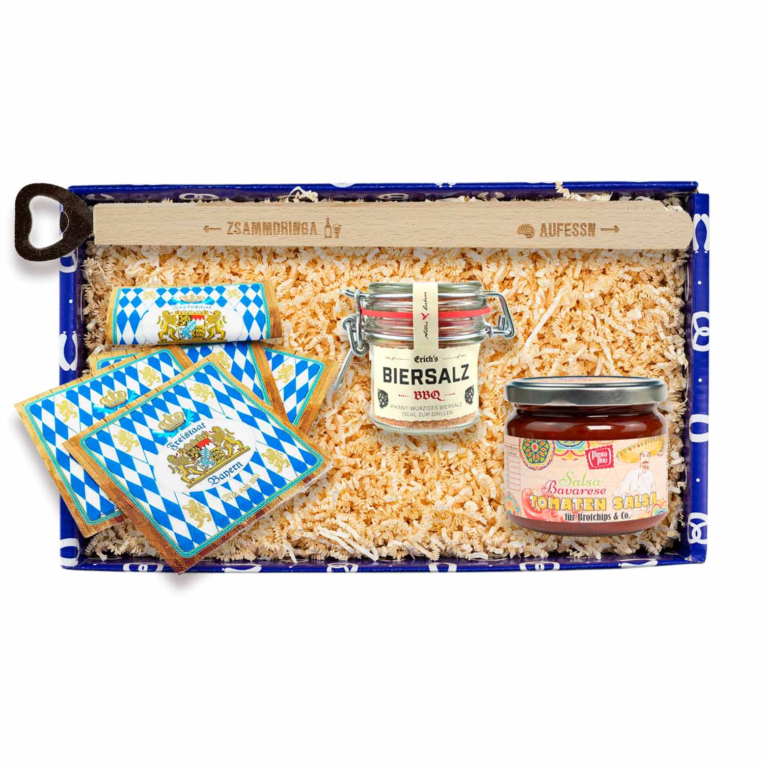 Geschenkbox mit Tomatensalsa, Grillzange mit Aufdruck „aufessn – zsammdringa“ und Servietten mit Rautenmuster.