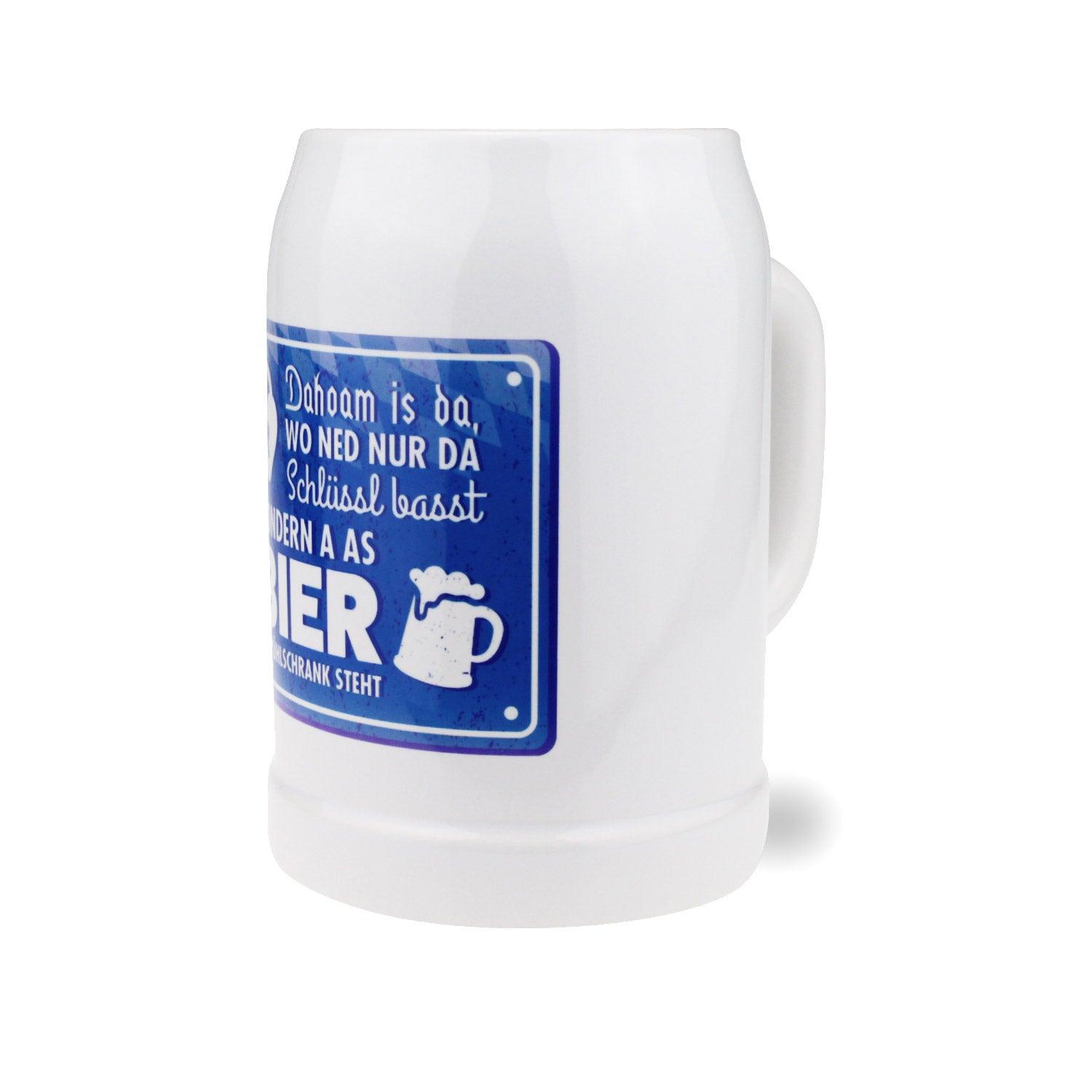 Weißer Bierkrug Dahoam mit blauem Spruchschild: Dahoam is da, wo ned nur da Schlüssl basst, sondern a Bier im Schrank steht.