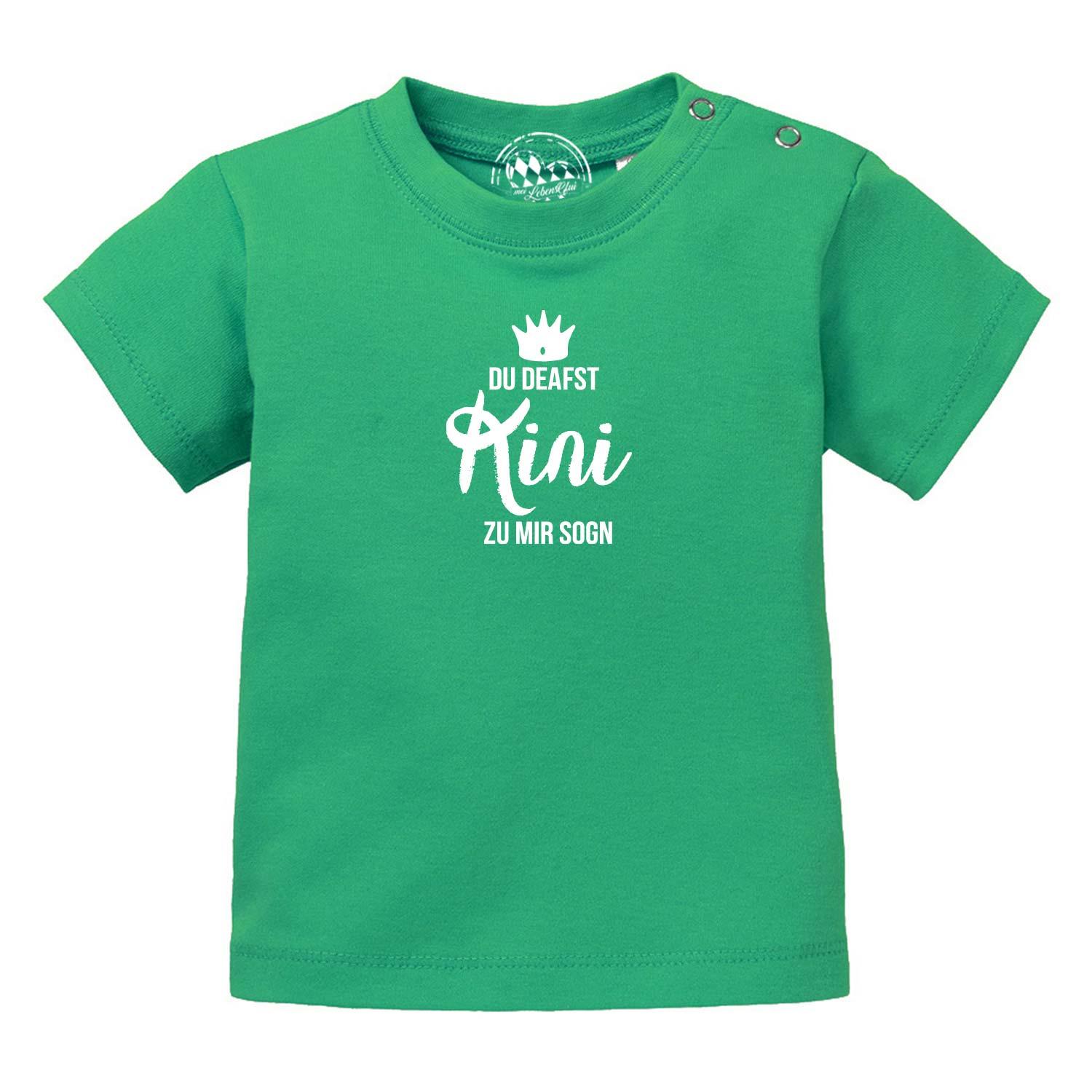 Grünes Baby T-Shirt "Kini" mit weißem bayerischen Aufdruck "DU DEAFST Kini ZU MIR SOGN" und Druckknöpfen an der Schulter.