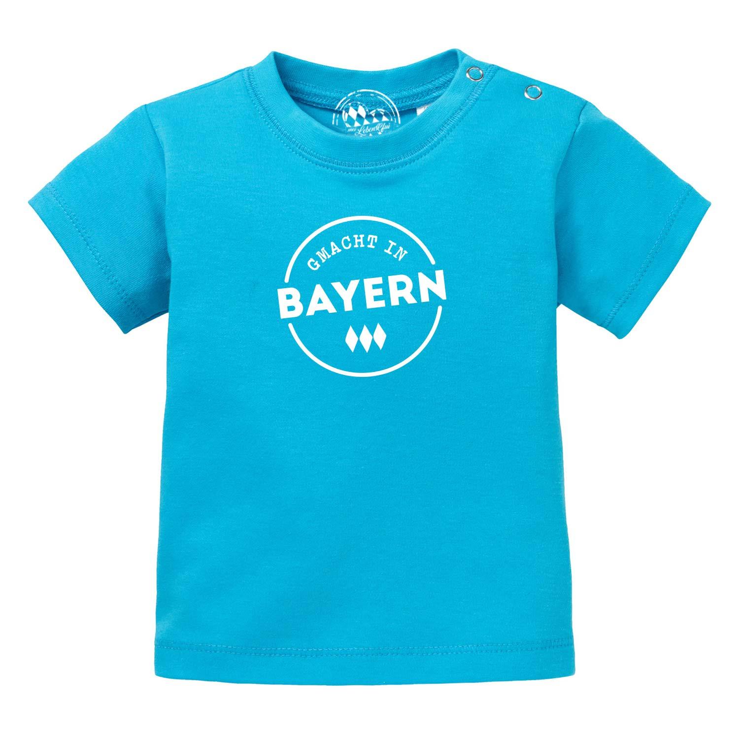 Baby T-Shirt Gmacht in Bayern in leuchtendem Türkis mit weißem "Gmacht in Bayern" Aufdruck und Druckknöpfen.