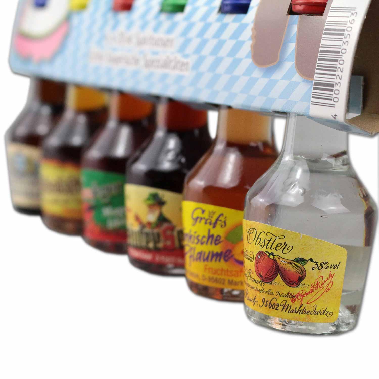 Sechs kleine Flaschen mit bayrischen Likören und Obstbränden in klarer Glasoptik mit bunten Etiketten, je 0,02 l.