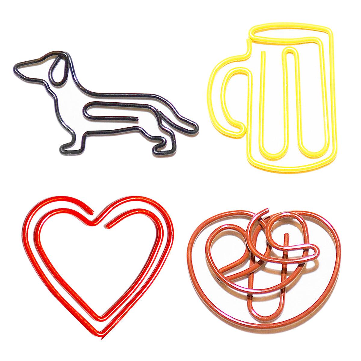 Acht bayrische Büroklammern aus Metall in vier humorvollen Formen wie Brezel, Hut, Herz und Maßkrug.