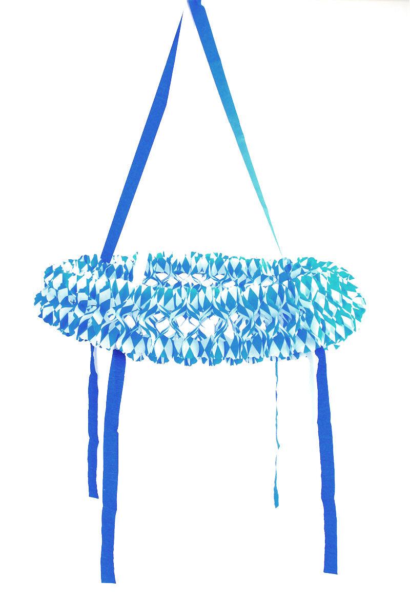 Runder Seidenpapierkranz in Blau und Weiß mit traditionellem Rautenmuster, bayerisches Dekorationsdesign.