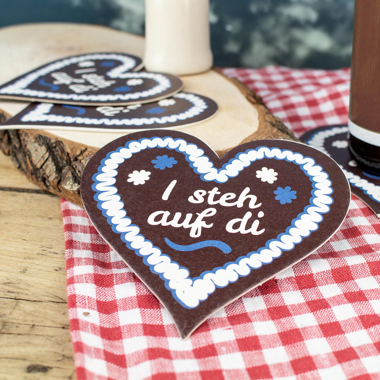 Herzförmiger Bierdeckel mit Lebkuchenherz-Motiv und weißem Schriftzug „I steh auf di“, im Set zu 20 Stück.