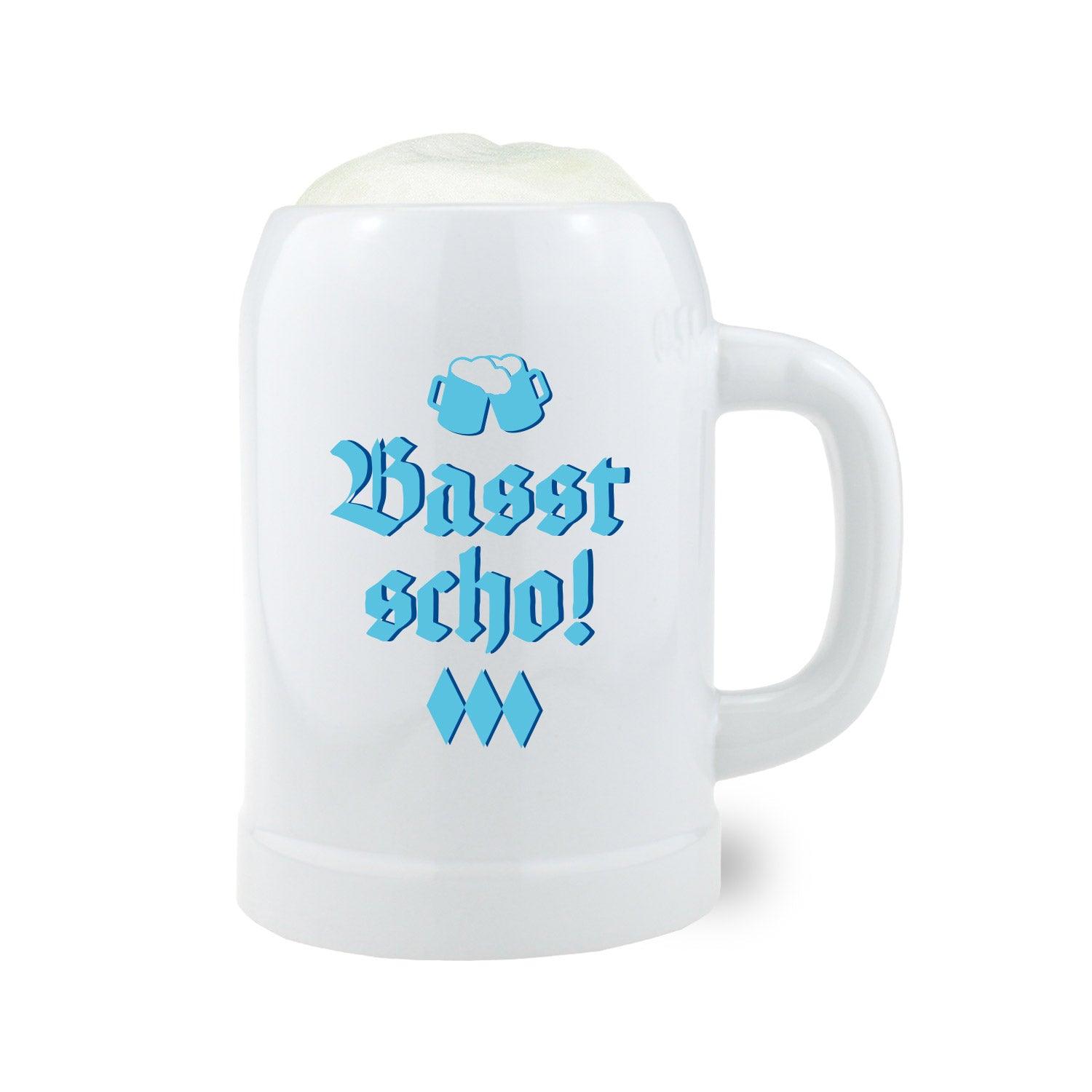 Weißer Bierkrug mit blauem Schriftzug „Basst scho“ und Bayern-Wappen, zylindrische Form, Keramik, 0,5 Liter.