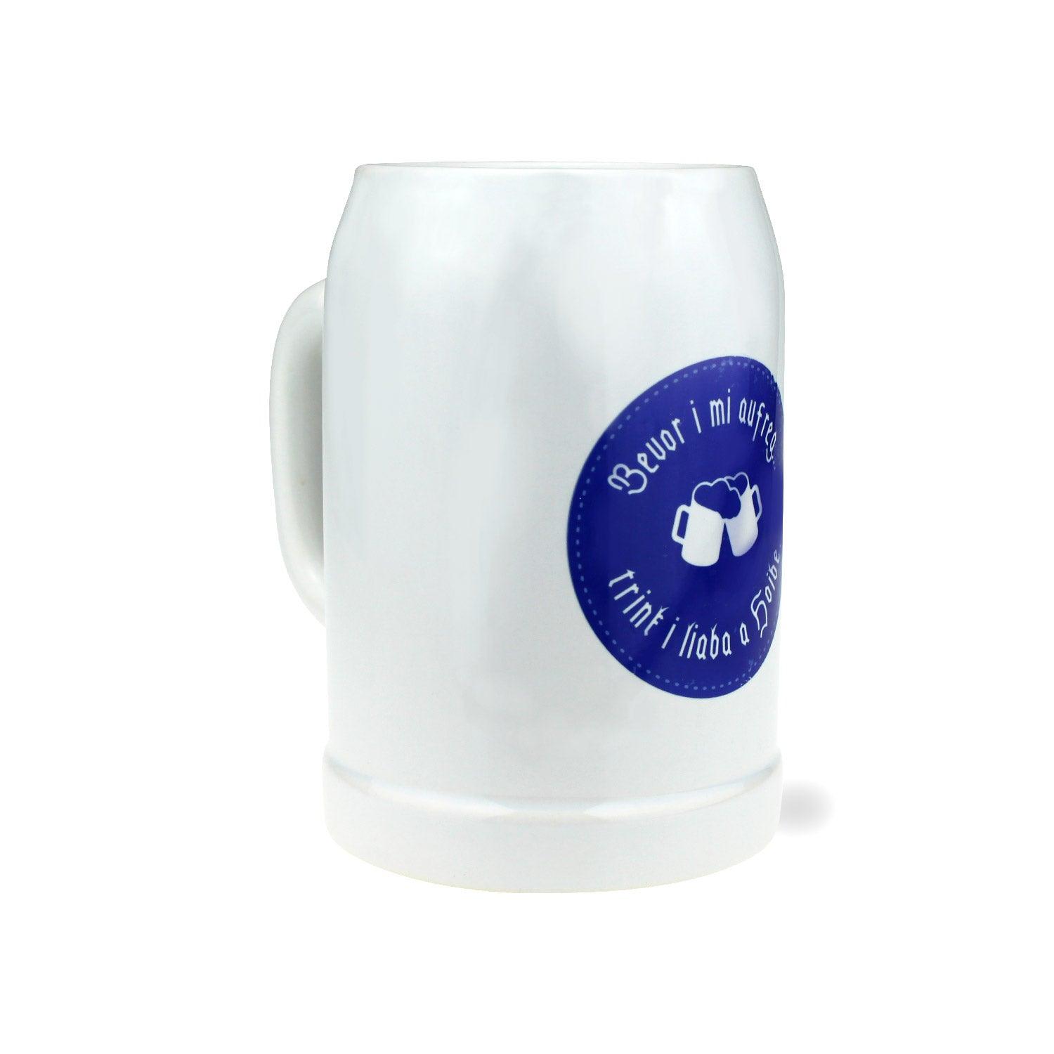 Weißer Bierkrug mit bauchiger Form, blauem bayerischen Rautenmuster und Schriftzug „bevor i mi aufreg“, 0,5 l, Keramik.