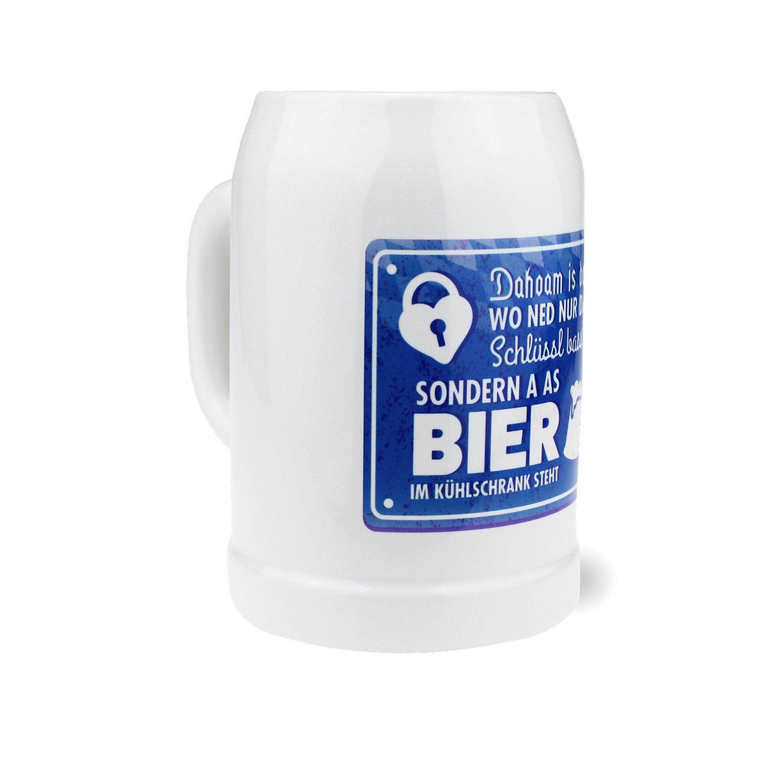 Weißer Bierkrug Dahoam mit blauem Spruch "Dahoam is wo ned nur im Kühlschrank a Bier steht".