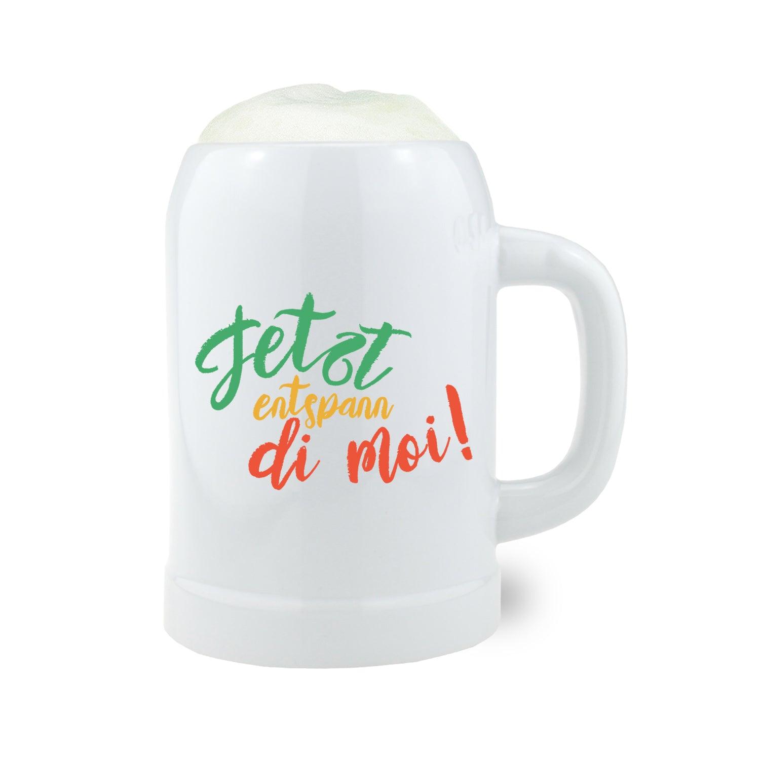 Bierkrug aus Steinzeug mit Henkel, bauchiger Form und Schriftzug „Entspann di moi“, Füllmenge 0,5 Liter, ca. 126 mm hoch.