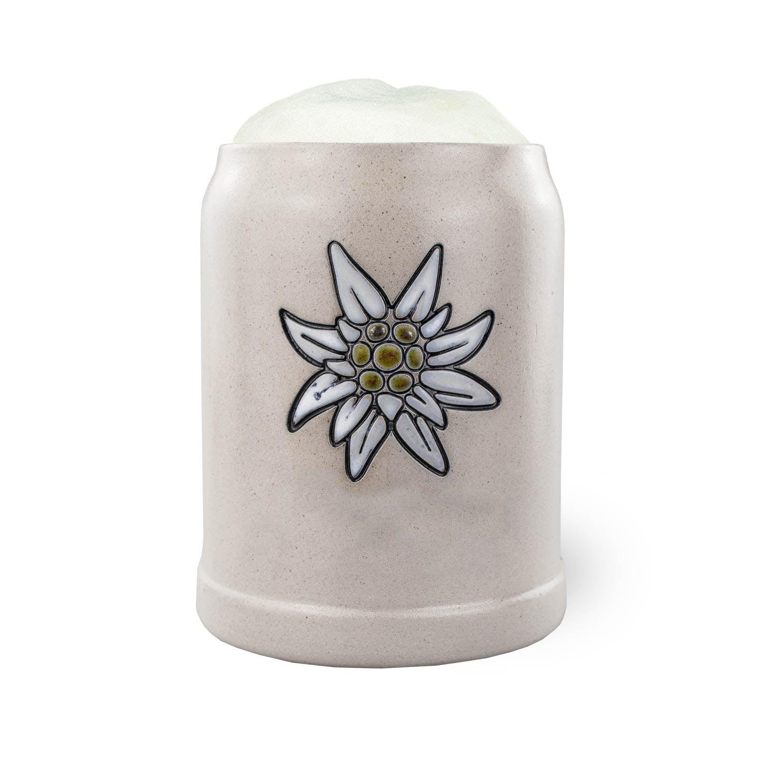 PREMIUM Bierkrug Edelweiß aus Keramik, gefüllt mit frischem Bier und Schaumkrone, weißer Hintergrund.