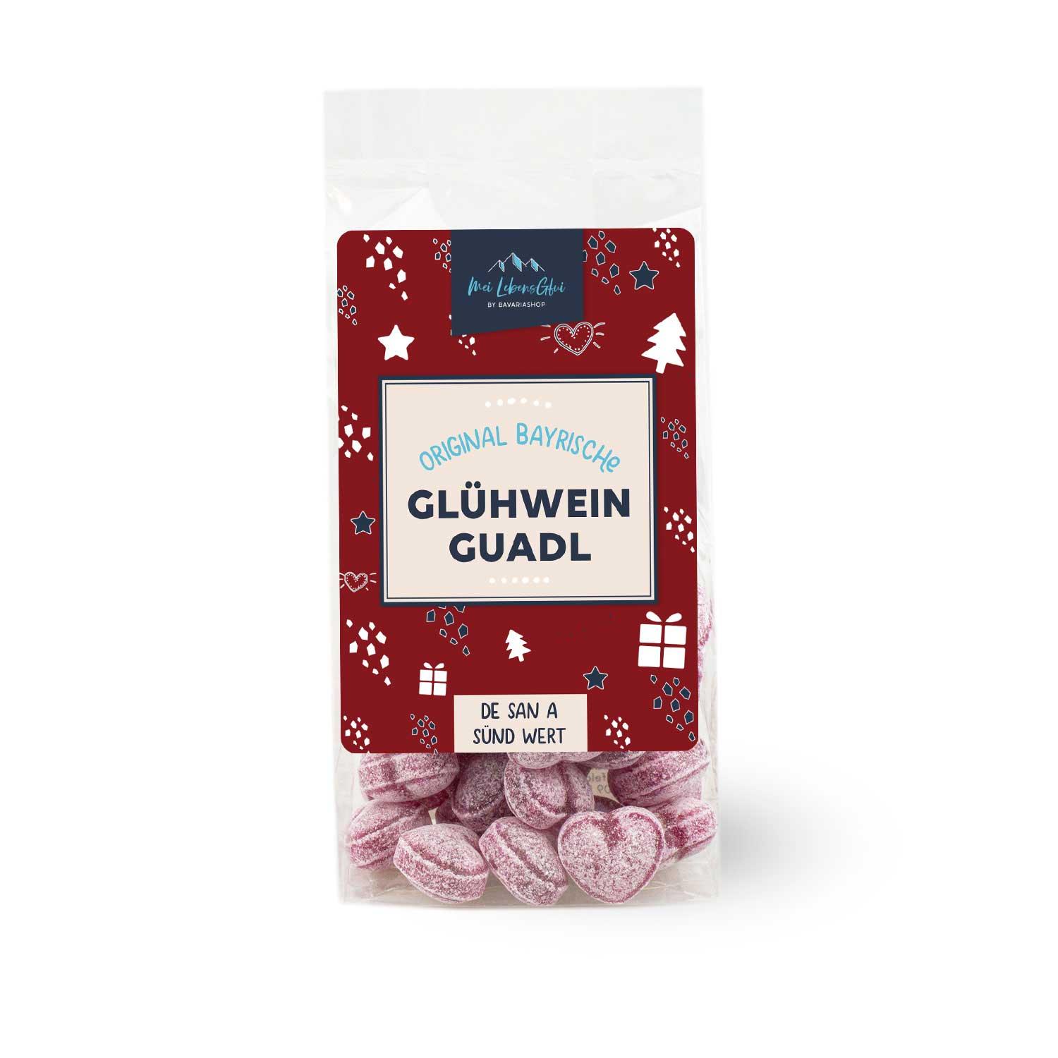 Weihnachtliche Geschenkbox mit Heidelbeer-Glühwein, Tasse mit „Glühwein“-Schriftzug und Glühwein-Bonbons.