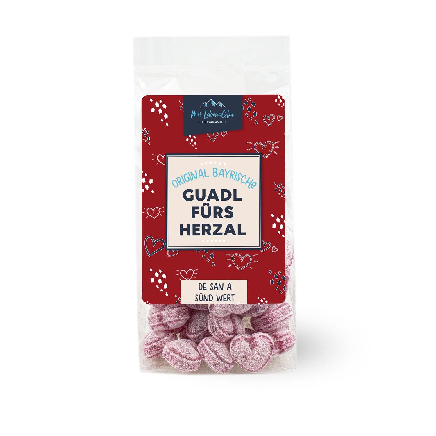 Herzförmige Bonbons in Rot und Rosa mit weißem Aufdruck „I mog di“, aus Zucker, ungefüllt, alkoholfrei, 150 g.