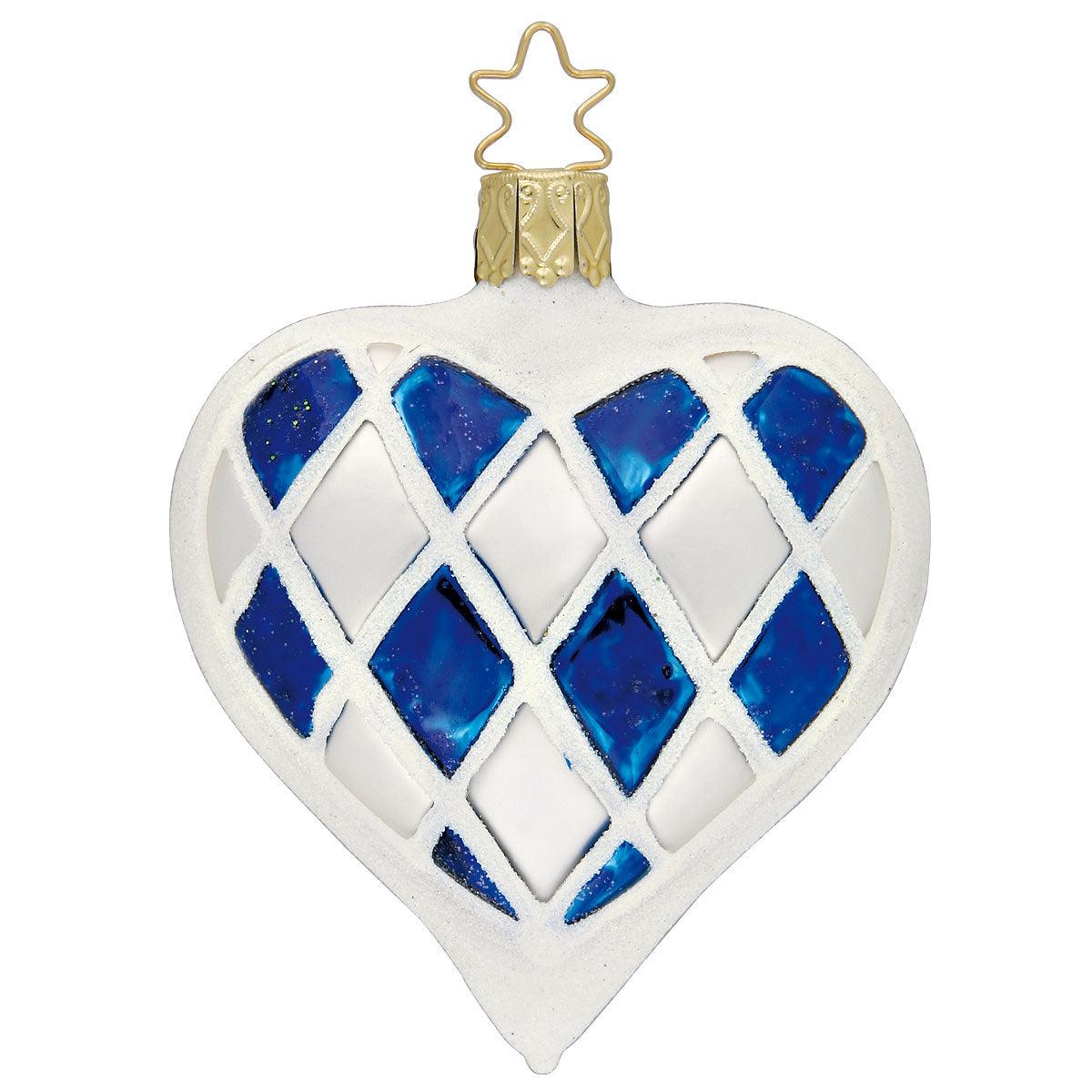 Herzförmiger Christbaumschmuck aus mundgeblasenem Glas in Blau-Weiß mit Edelweiß-Motiv und verzierter Schrift.