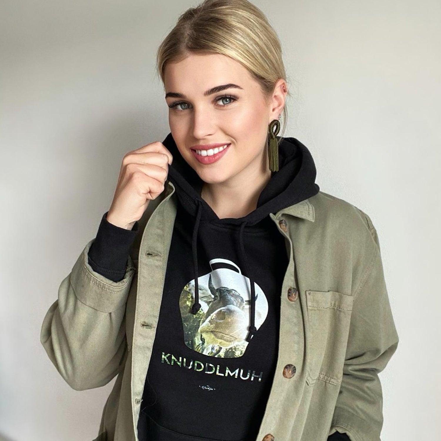 Damen Hoodie in Beige mit Kuh-Motiv und Schriftzug „Knuddlmuh“, aus Bio-Baumwolle und recyceltem Polyester.