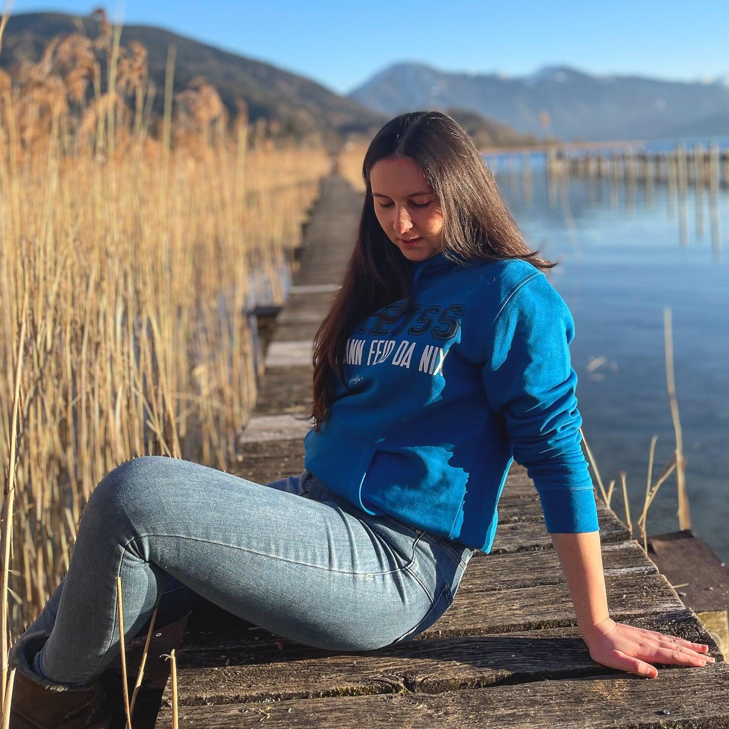 Damen Hoodie in Dunkelgrau mit Kapuze, Front-Aufdruck „Scheiß da nix“ in Weiß, aus Bio-Baumwolle.