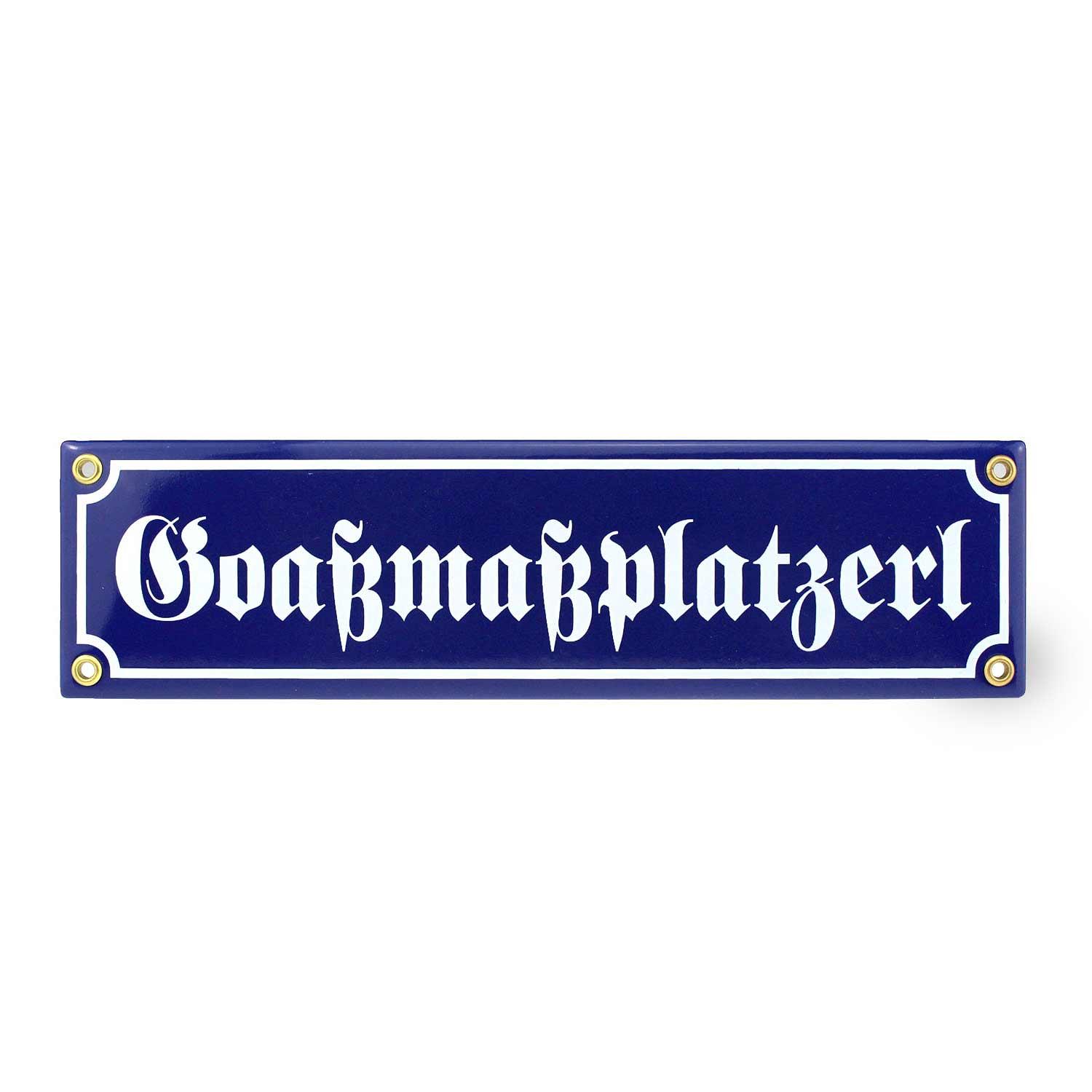 Rechteckiges Emaille-Schild mit weißem Schriftzug „Goaßmaßplatzerl“ auf schwarzem Hintergrund, mit Metallösen.