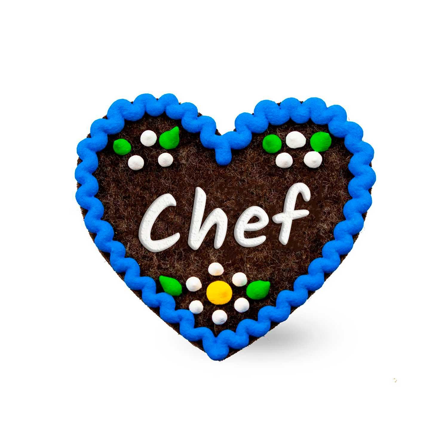 Herzförmiger Filz-Anstecker mit gesticktem Schriftzug „Chef“ und Sicherheitsverschluss auf der Rückseite; ca. 6,5 x 7 cm, 3 mm dick.