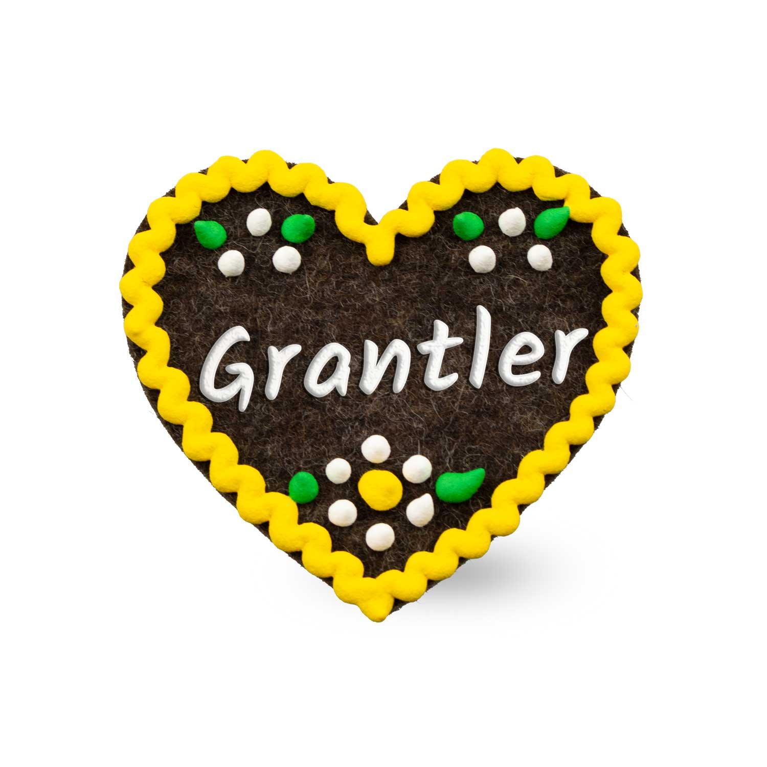 Herzförmiger Filz-Anstecker mit aufgesticktem Schriftzug „Grantler“ und Sicherheitsverschluss auf der Rückseite; ca. 6,5 x 7 cm, 3 mm dick.