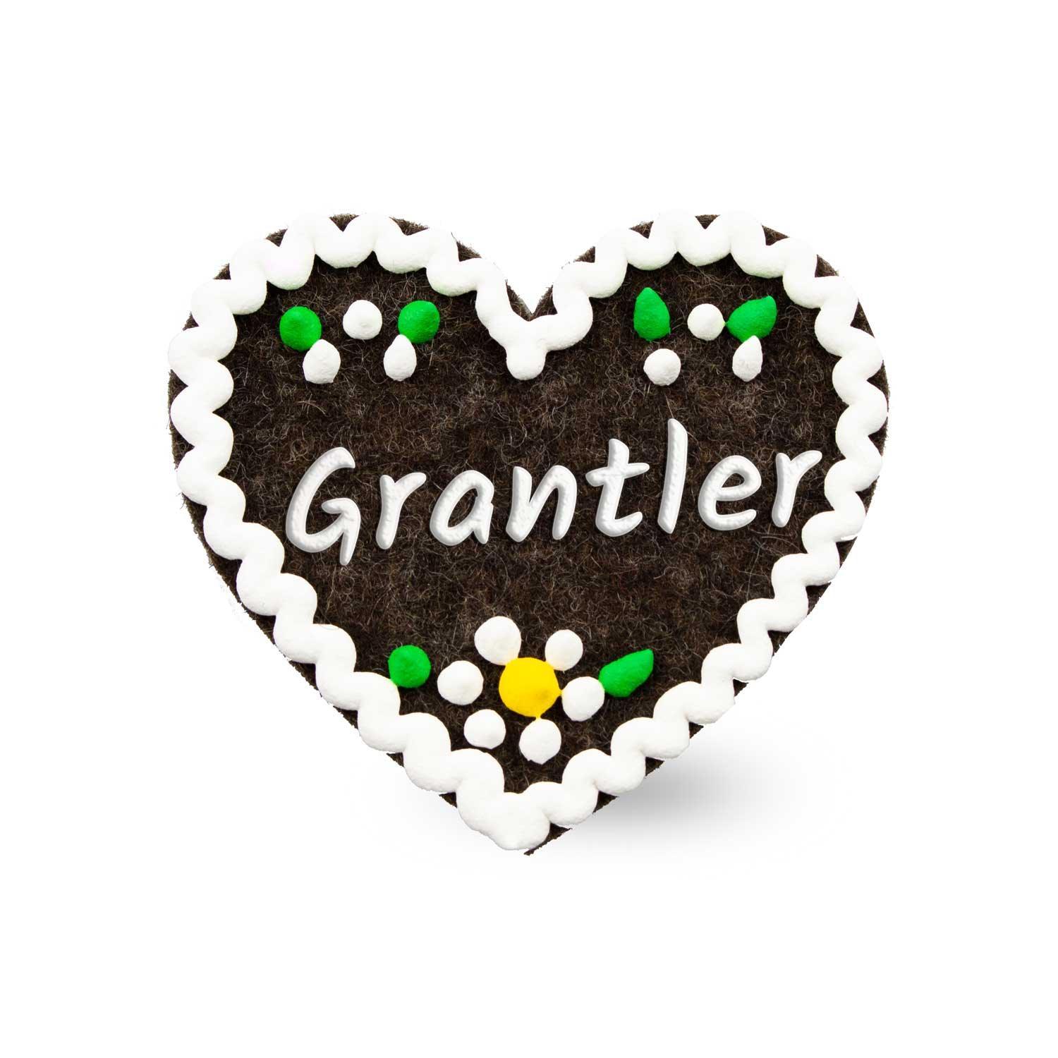 Herzförmiger Filz-Anstecker mit aufgenähtem Schriftzug „Grantler“, Sicherheitsverschluss auf Rückseite, ca. 6,5 x 7 cm.