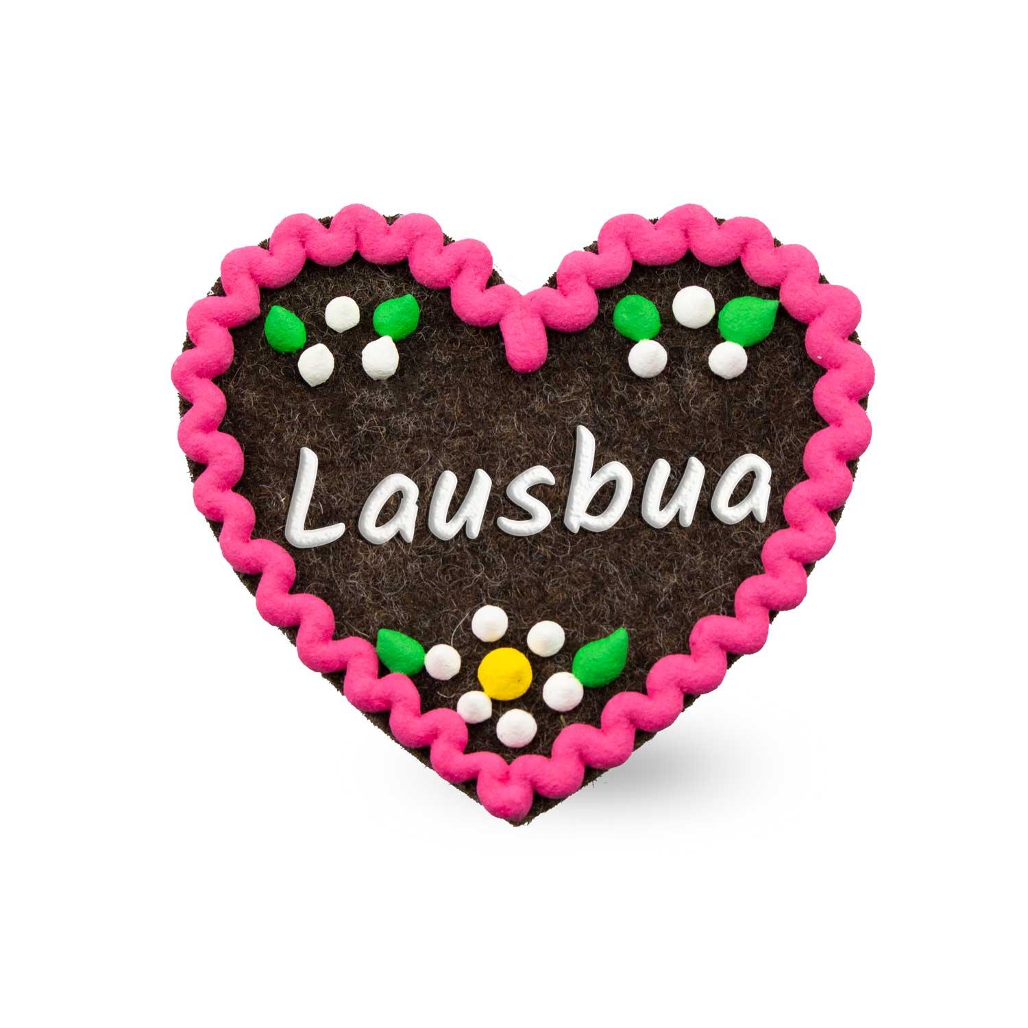 Herzförmiger Filz-Anstecker mit aufgesticktem Schriftzug „Lausbua“ und Sicherheitsverschluss auf der Rückseite, ca. 6,5 × 7 cm.