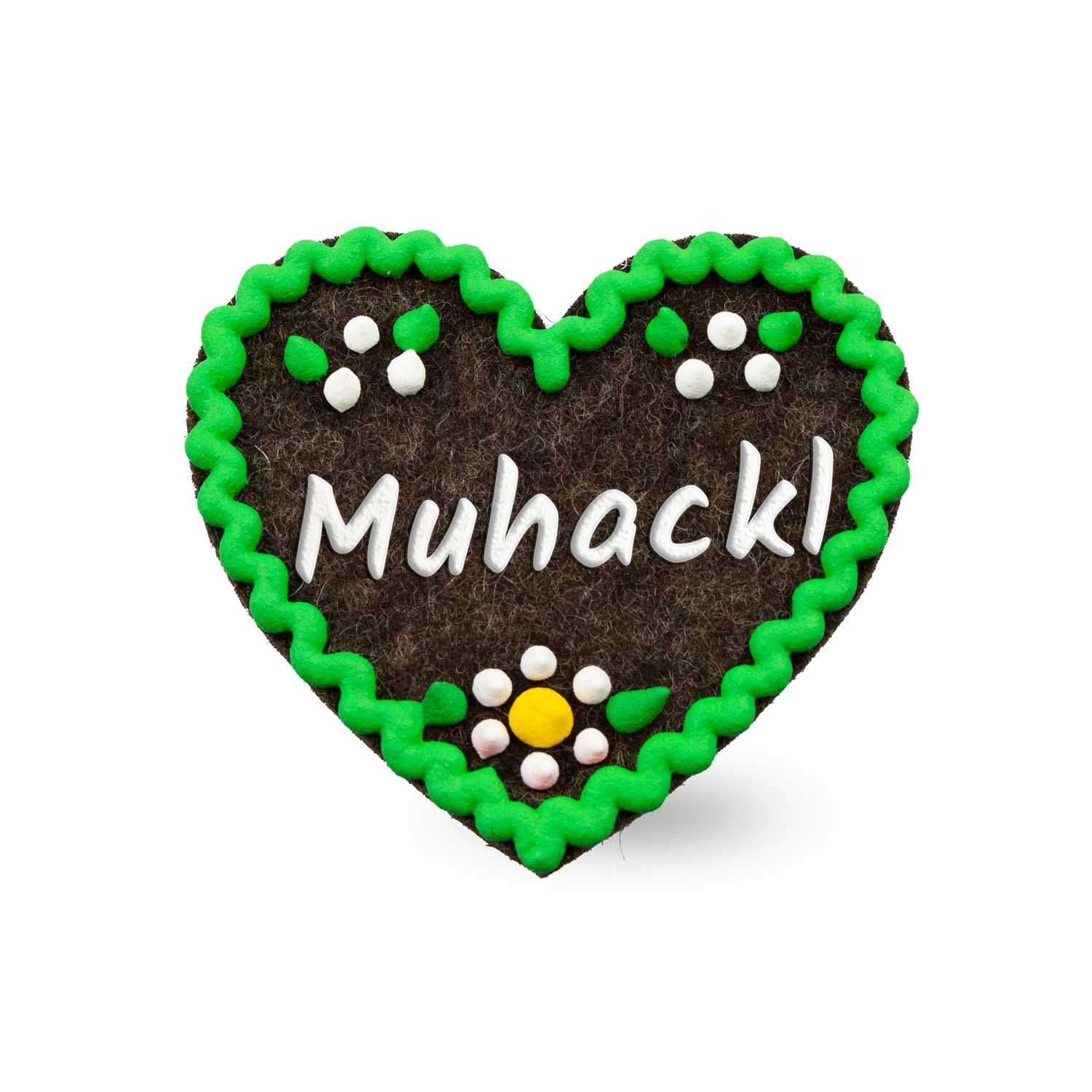 Herzförmiger Filz-Anstecker mit Hirschmotiv und Schriftzug „Muhackl“, Rückseite mit Sicherheitsverschluss, ca. 6,5 x 7 cm.