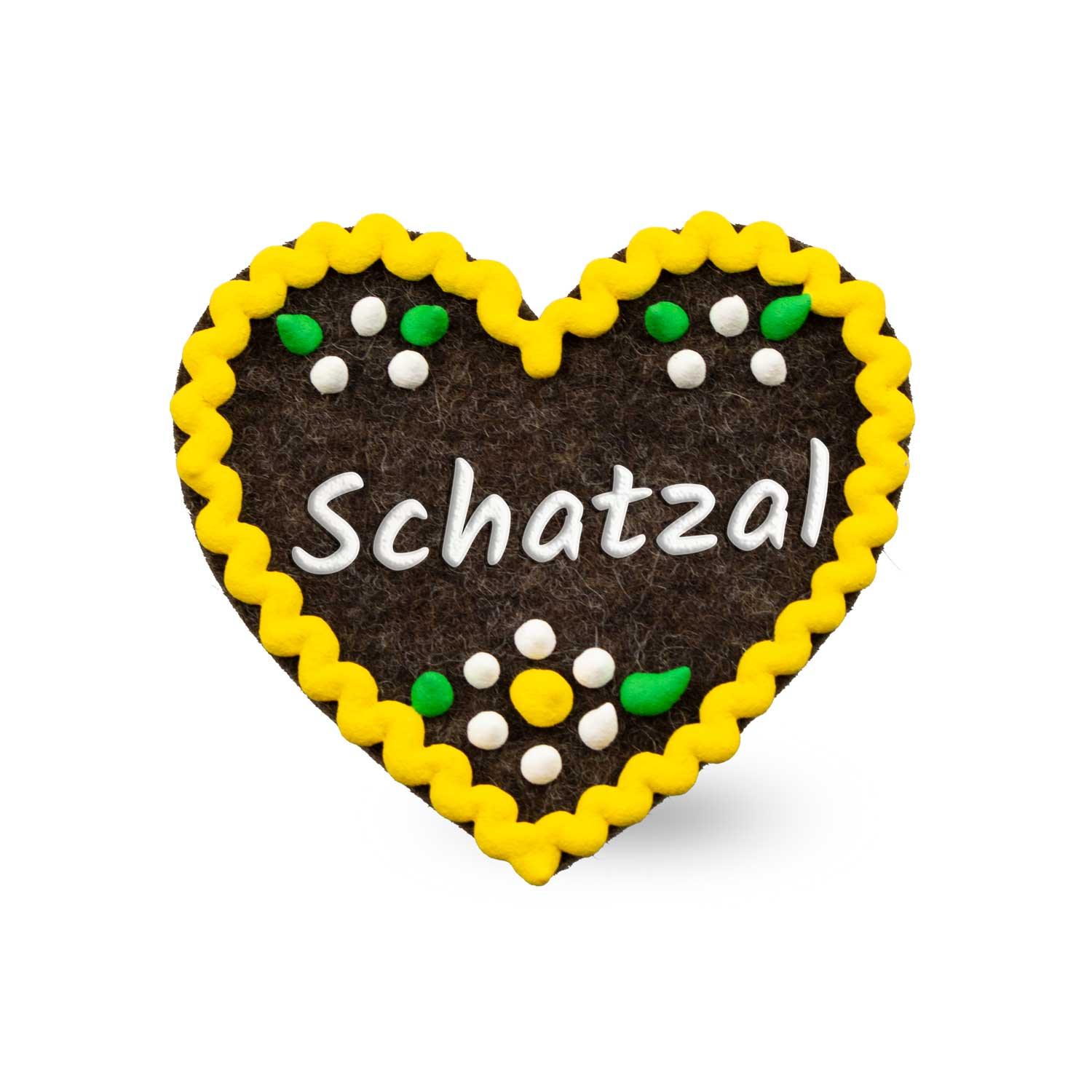Herzförmiger Filzanstecker mit gesticktem Schriftzug „Schatzal“ und Sicherheitsverschluss auf der Rückseite; ca. 6,5 x 7 cm, 3 mm dick.