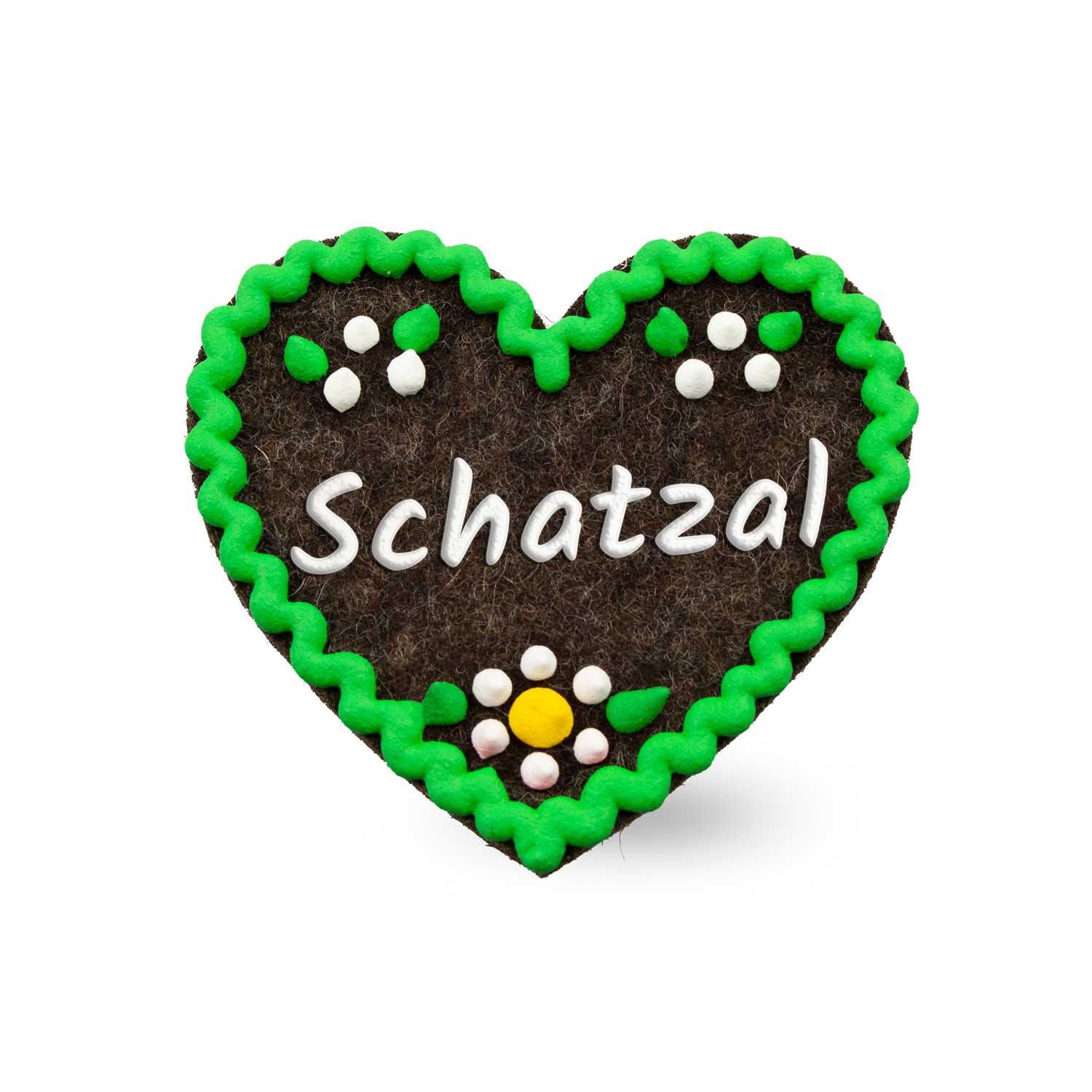 Herzförmiger Filz-Anstecker mit gesticktem Schriftzug „Schatzal“, Sicherheitsverschluss auf der Rückseite, ca. 6,5 x 7 cm.